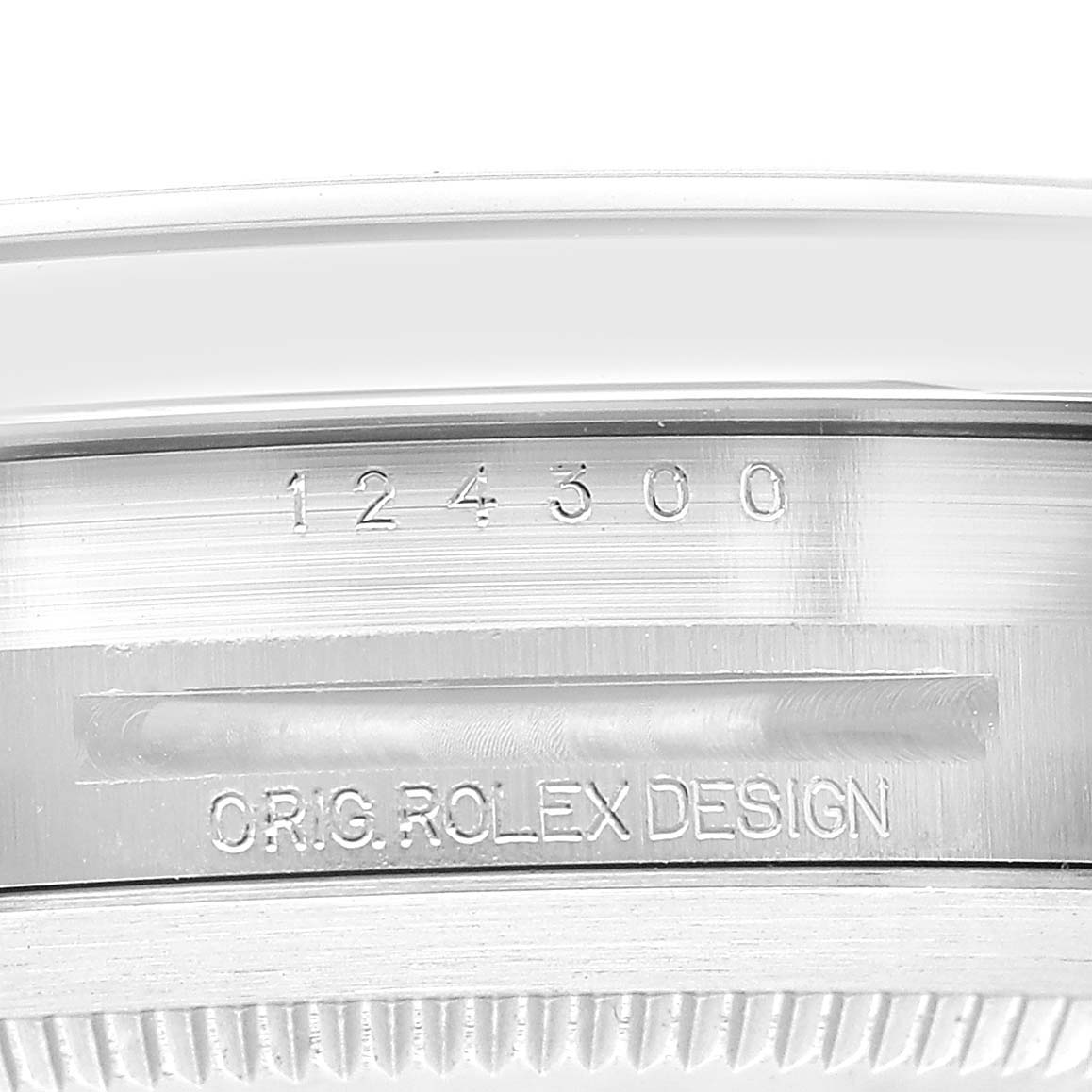The image shows a close-up of the side of a Rolex Oyster Perpetual 124300 Men's Stainless Steel Blue Dial watch case with engraved model number and "ORIG ROLEX DESIGN."