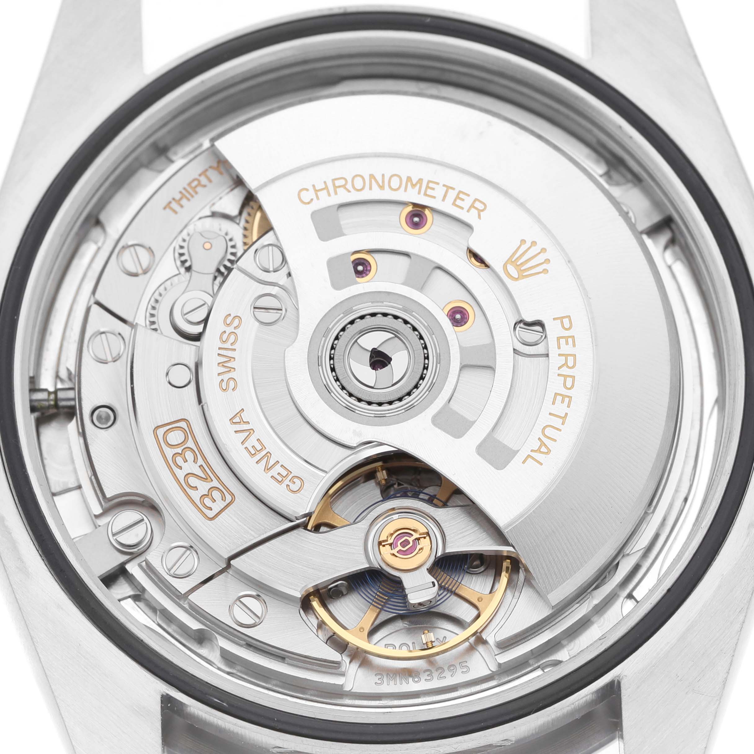 The image shows the movement of a Rolex Oyster Perpetual 124300 Men's Stainless Steel Silver Dial watch from the back, highlighting the rotor and intricate mechanisms.