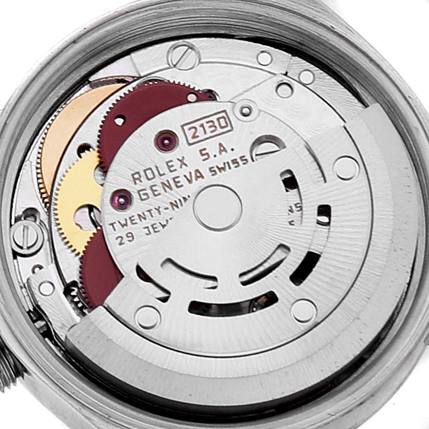 The image shows the internal mechanism of a Rolex Oyster Perpetual 67193 Women
s Steel and Gold (two tone) Champagne Dial 67193 Women
s Steel and Gold (two tone) Champagne Dial model, focusing on the intricate gears and parts of the watch movement.