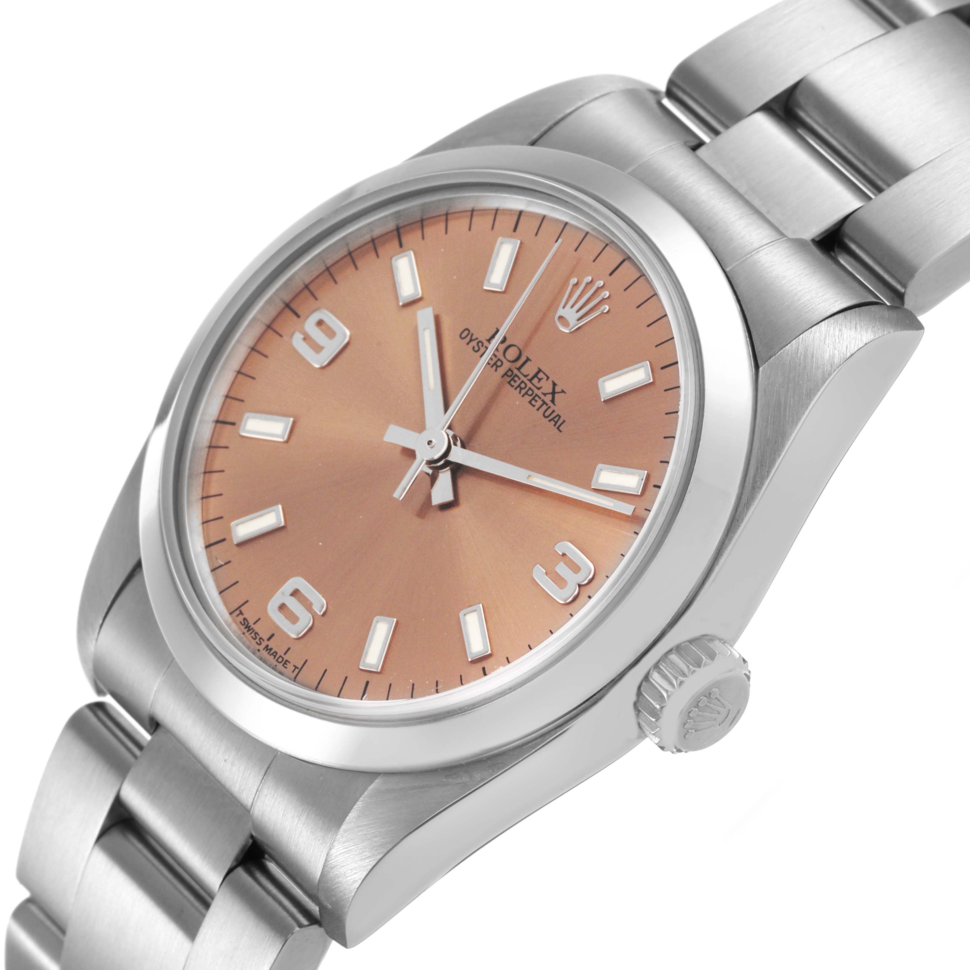 The Rolex Mid-Size 67480 Women's Stainless Steel Pink Dial watch is shown at a three-quarter angle, displaying its dial, bezel, crown, and part of the bracelet.