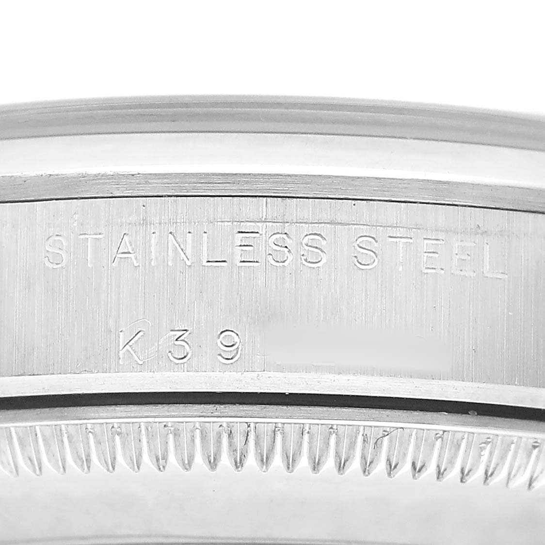 The image shows a close-up of the side engraving on the Rolex Oyster Perpetual 77080 Women's Stainless Steel Silver Dial, highlighting "STAINLESS STEEL" and serial details.