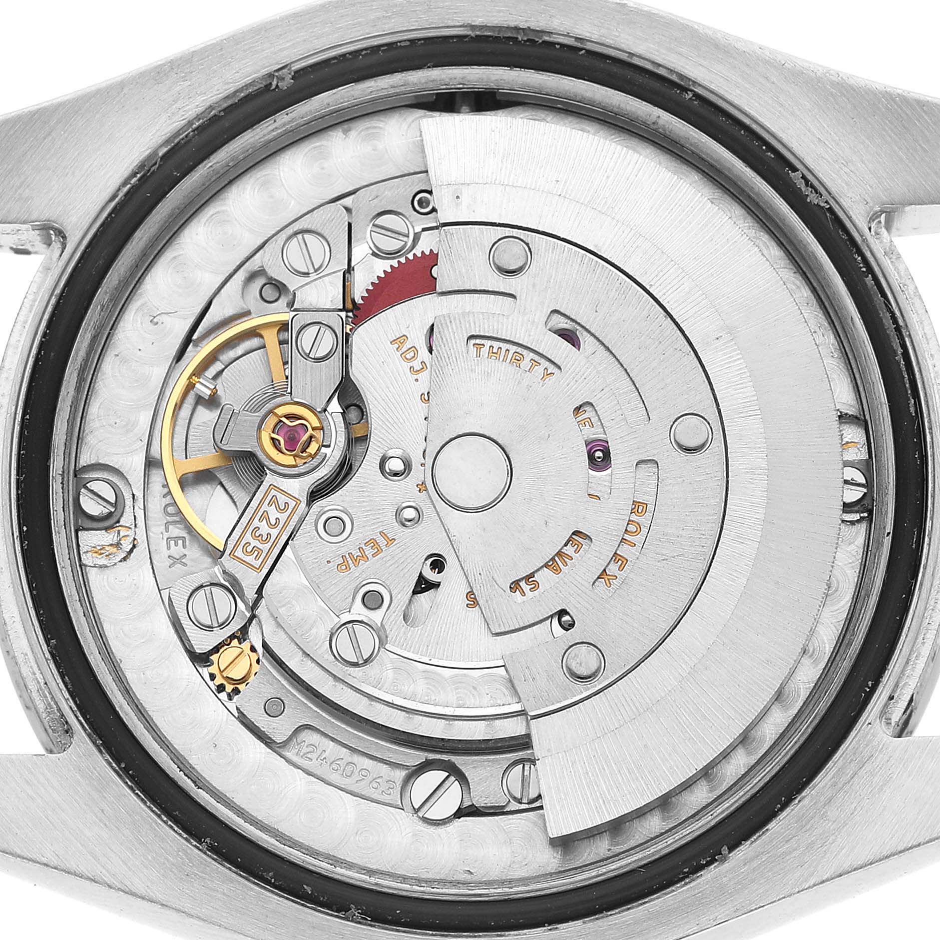 The image shows the movement of a Rolex Oyster Perpetual 77080 Women's Stainless Steel Silver Dial watch from the back, including gears and the rotor.