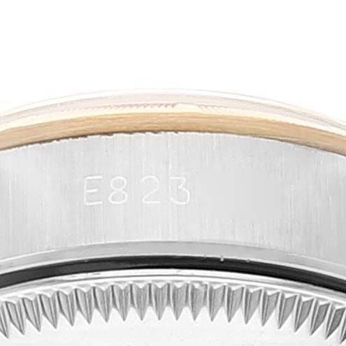 The image shows a side view of the bezel and the upper part of the case of a Rolex Oyster Perpetual 67233 Women
s Steel and Gold (two tone) Champagne Dial 67233 Women
s Steel and Gold (two tone) Champagne Dial watch, including the engraved serial number.