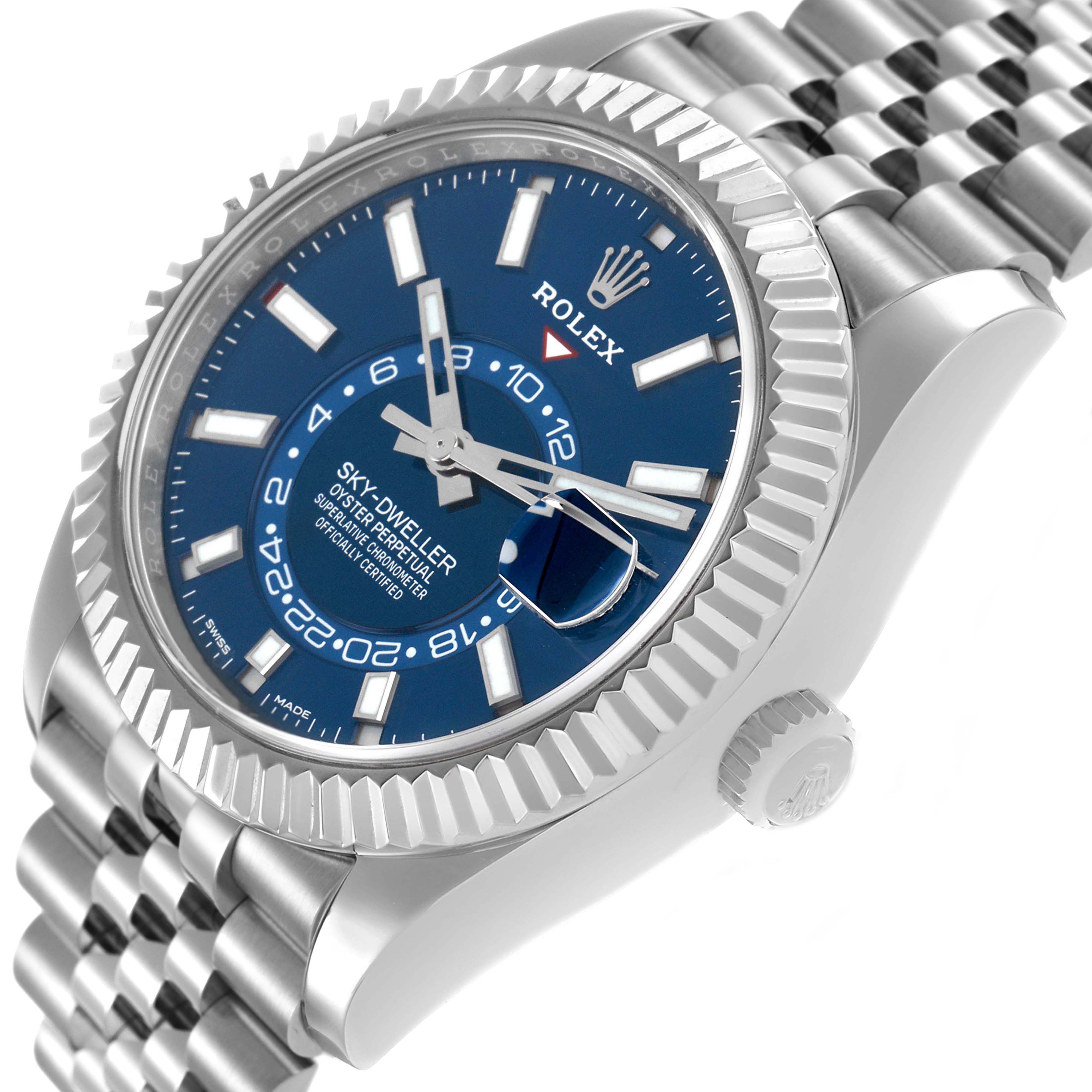 The Rolex Sky-Dweller 326934 Men's Stainless Steel Blue Dial watch is shown at an angle highlighting the blue dial, fluted bezel, crown, and bracelet.