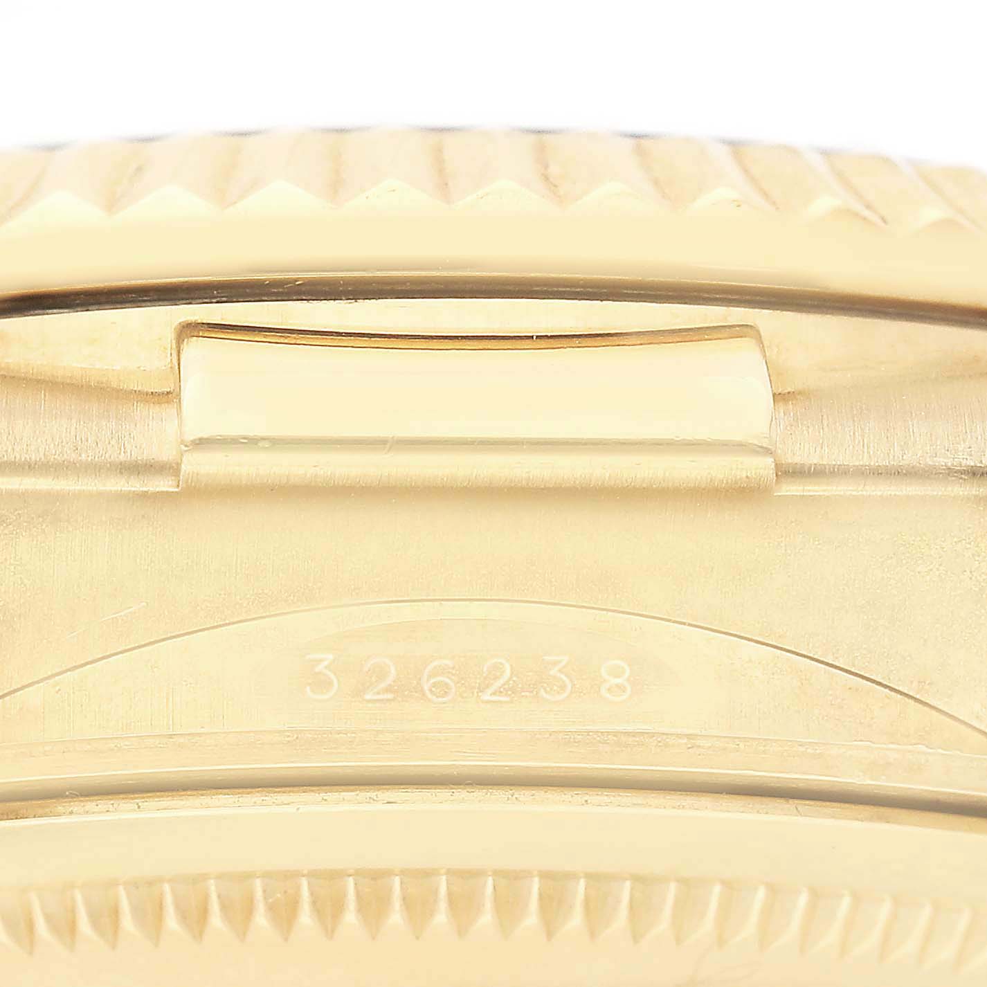 The image shows a close-up of the side of a Rolex Sky-Dweller 326238 Men's Yellow Gold White Dial, highlighting the edge of the bezel and a serial number.