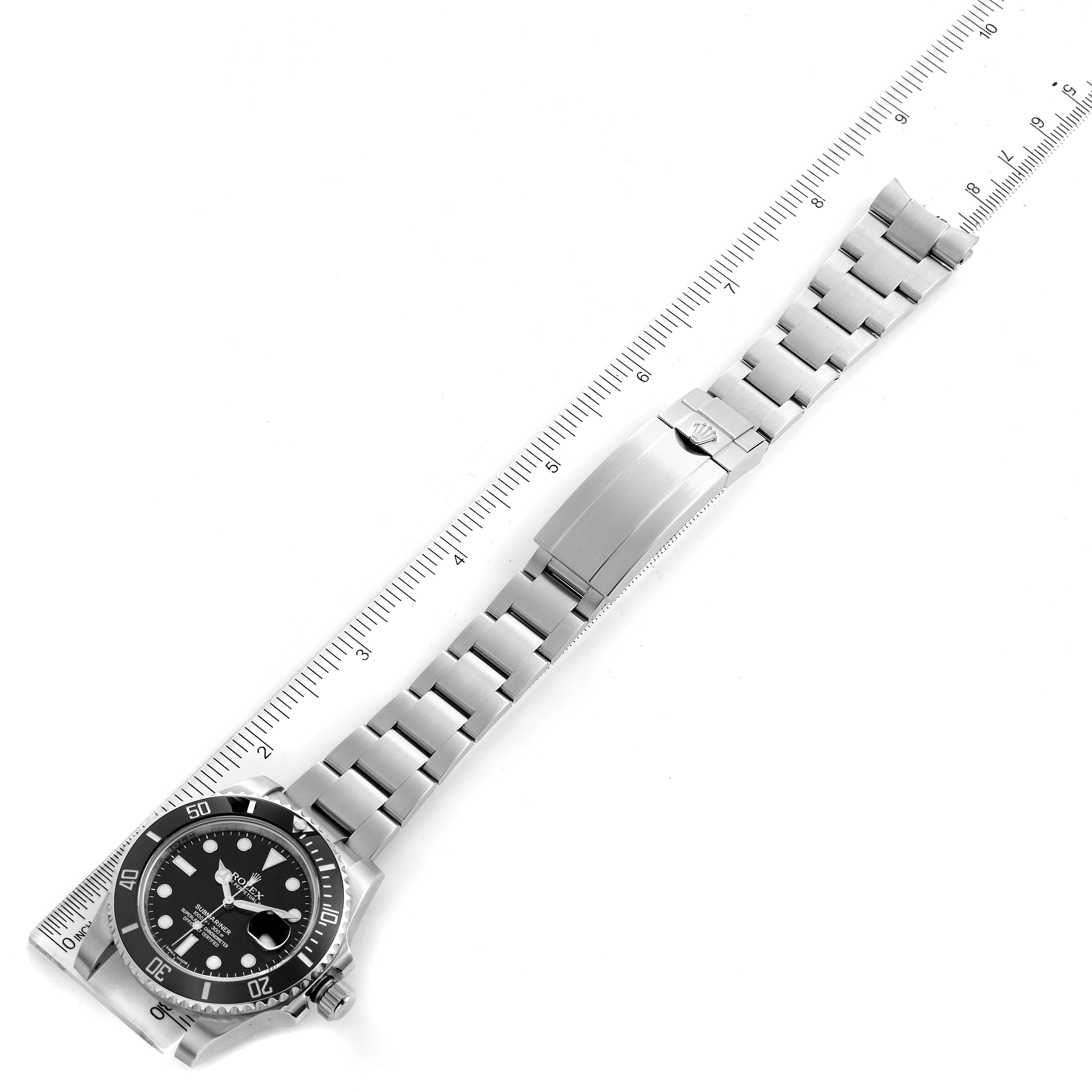 The image shows a top view of a Rolex Submariner 116610LN Men
s Stainless Steel Black Dial 116610LN Men
s Stainless Steel Black Dial watch, highlighting the face, bezel, and entire bracelet against a ruler backdrop.