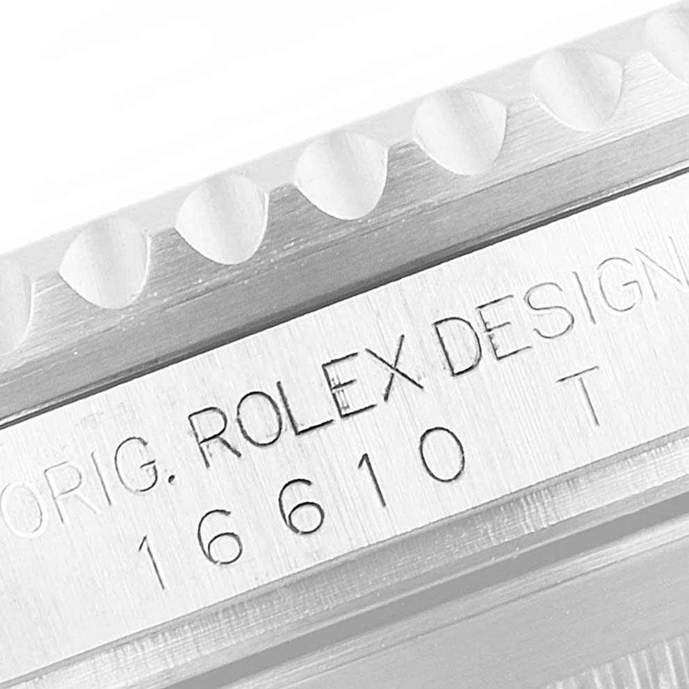 This image shows a close-up angle of a Rolex Submariner 16610 Men
s Stainless Steel Black Dial 16610 Men
s Stainless Steel Black Dial model
s case side with "ROLEX DESIGN" and model number engraving.