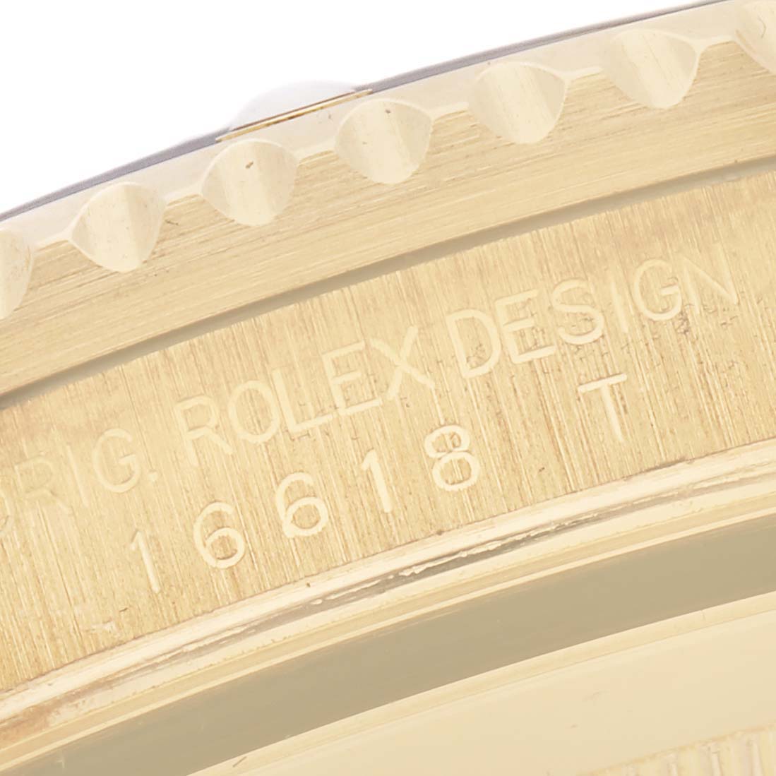 The image shows the side of a Rolex Submariner 16618 Men's Yellow Gold Blue Dial 16618 Men's Yellow Gold Blue Dial watch, focusing on the engraved bezel and model number.