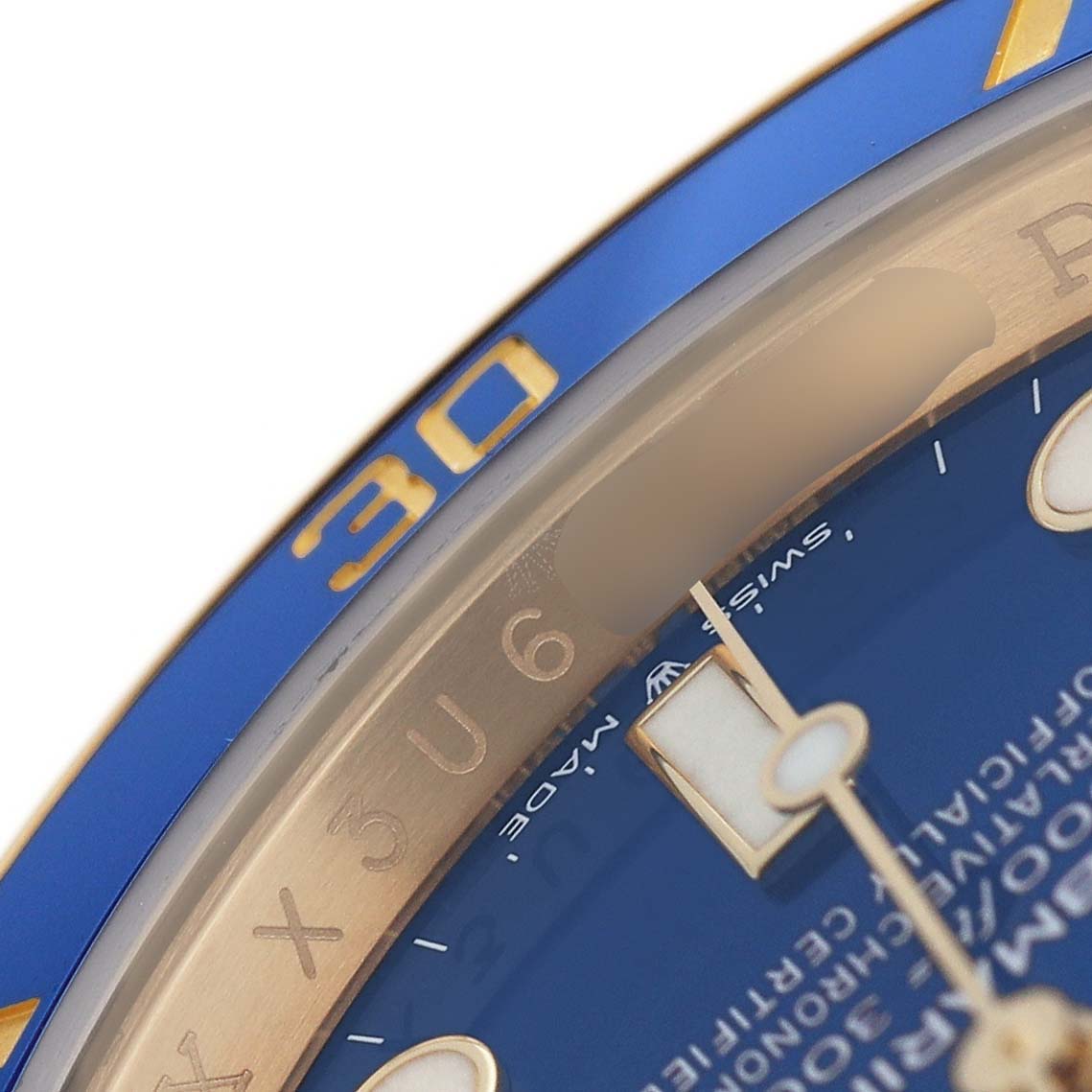 The image shows a close-up of a Rolex Submariner 126618LB Men's Yellow Gold Blue Dial watch, highlighting the bezel, dial, and part of the hands.