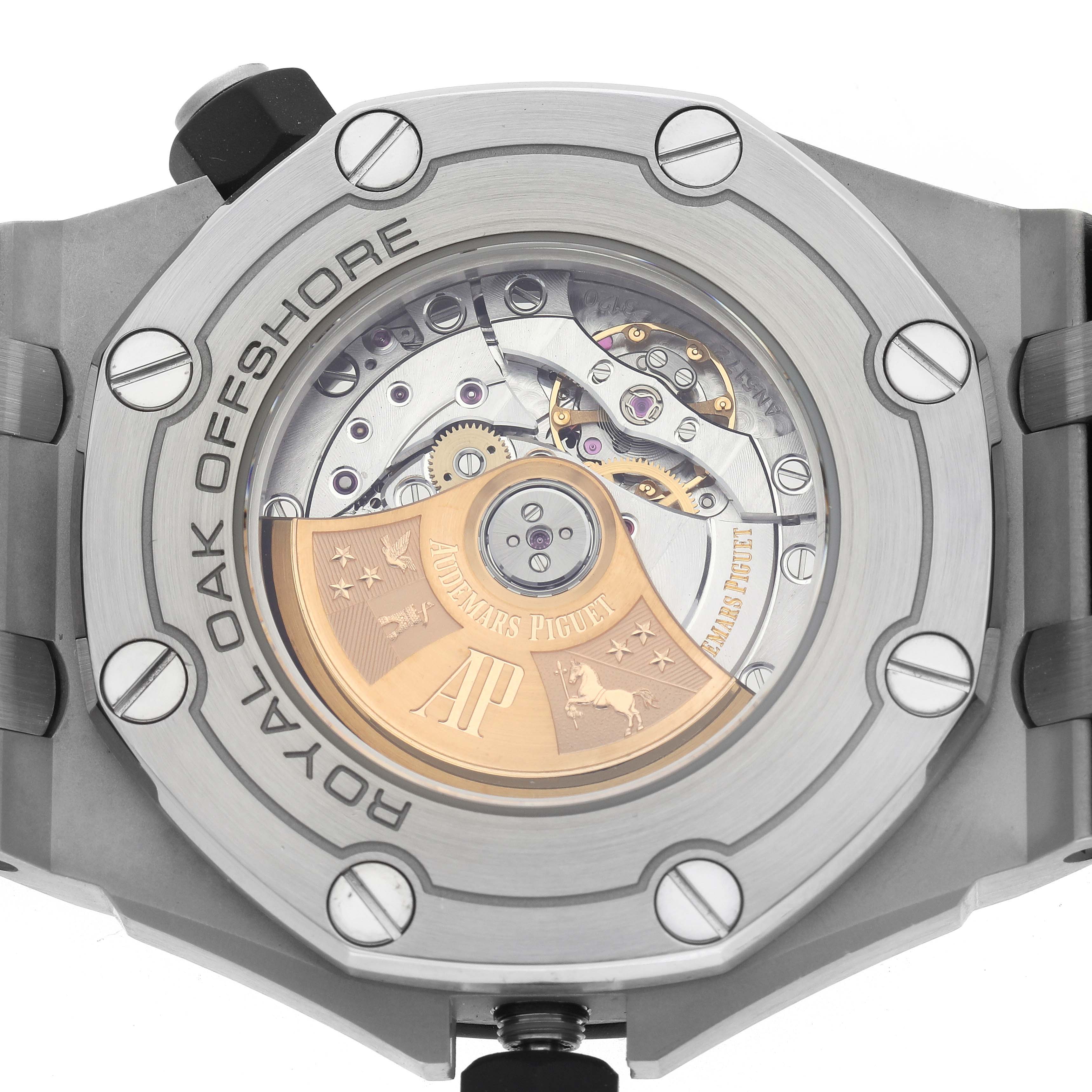 The image shows the case back of a Royal Oak Offshore by Audemars Piguet, highlighting the intricate movement and rotor.