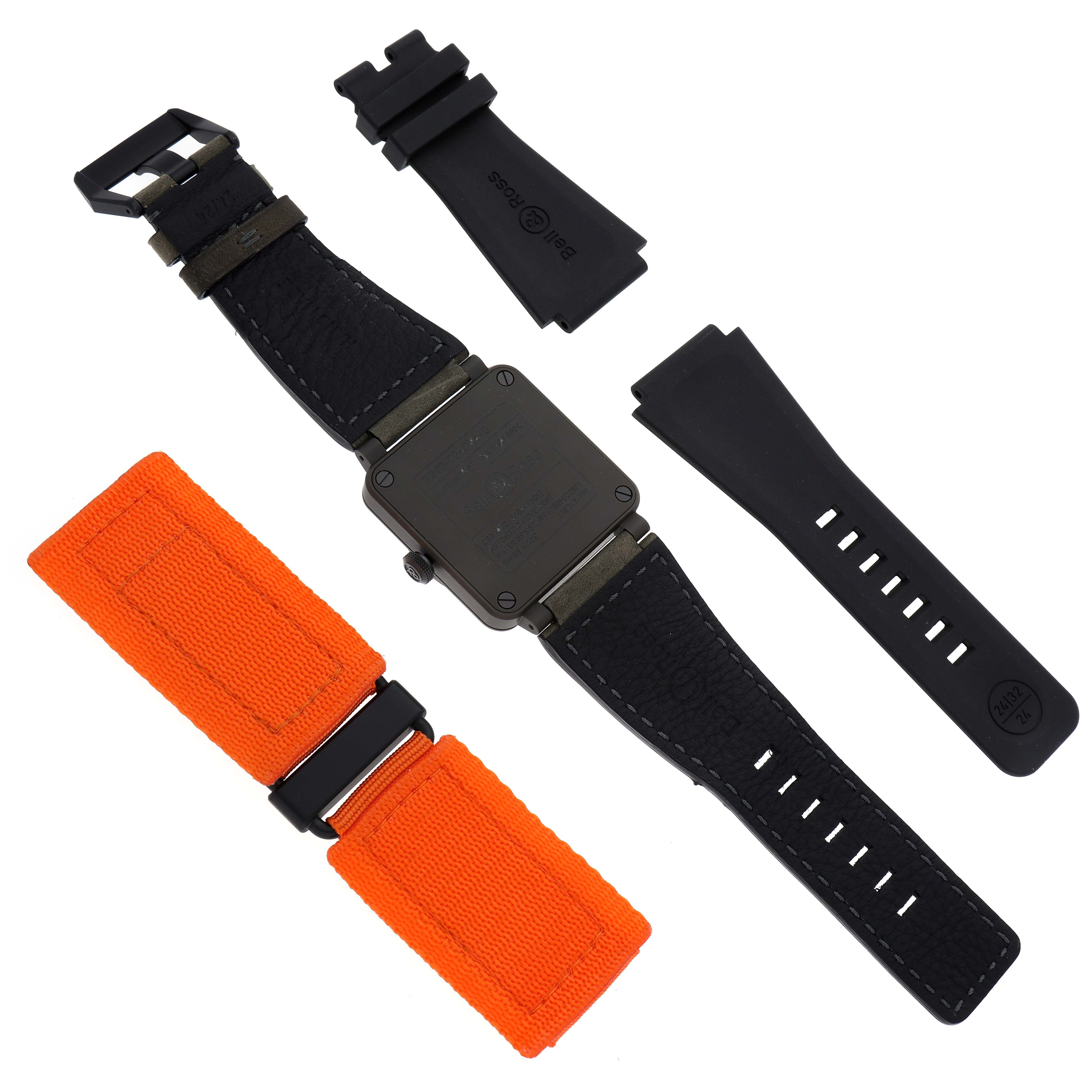 The Bell 
Ross Heritage BR03-92-CKA Men
s Ceramic Brown Dial BR03-92-CKA Men
s Ceramic Brown Dial watch is shown from the back with two strap options, one black and one orange, along with additional accessories.