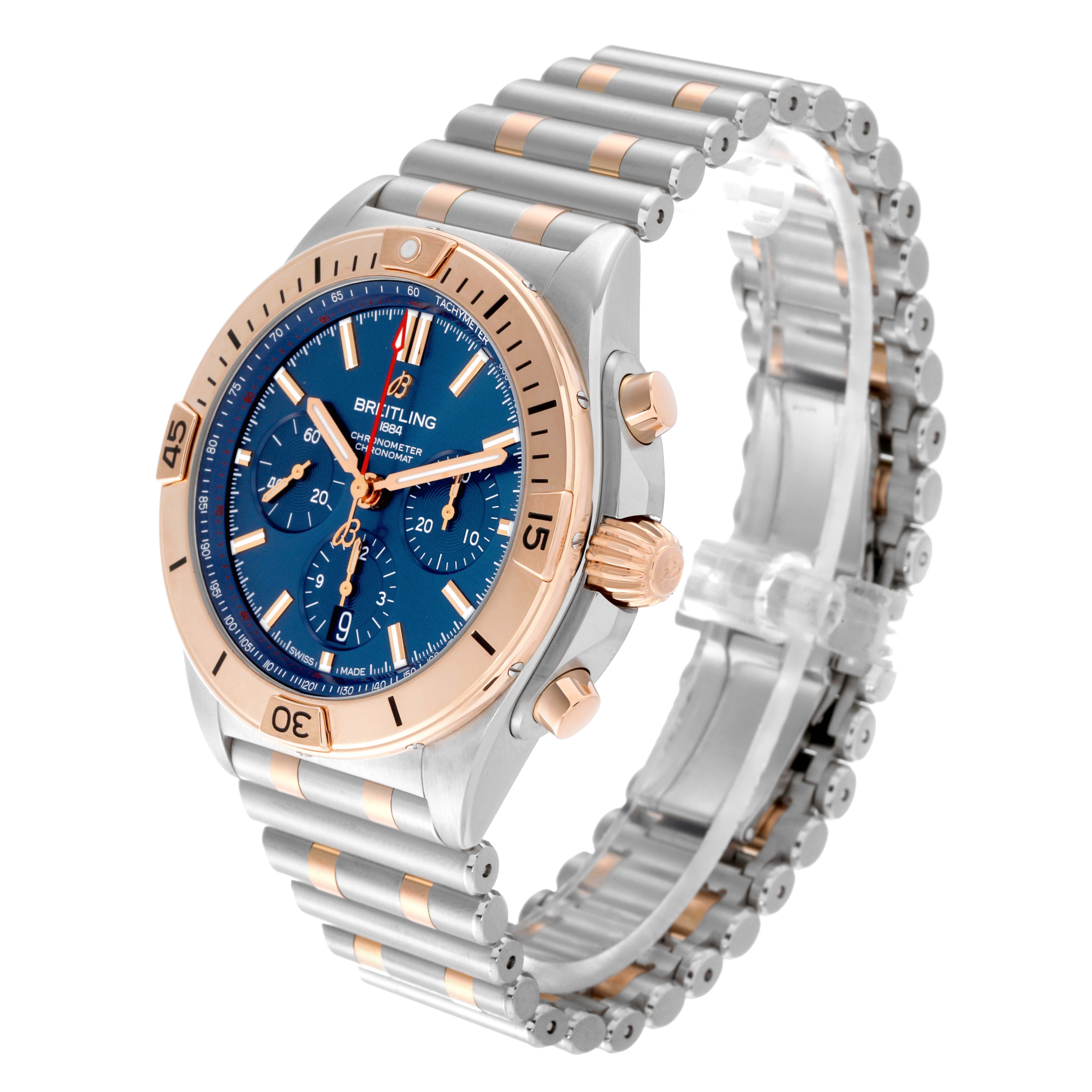 The Breitling Chronomat UB0134101C1U1 Men's Steel and Gold (two tone) Blue Dial watch is shown at an angled side view, displaying the bezel, dial, crown, pushers, and bracelet.