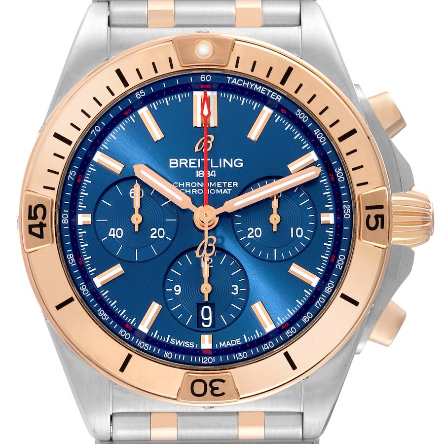 This image shows the face of a Breitling Chronomat watch with a gold and silver bezel and a blue dial.