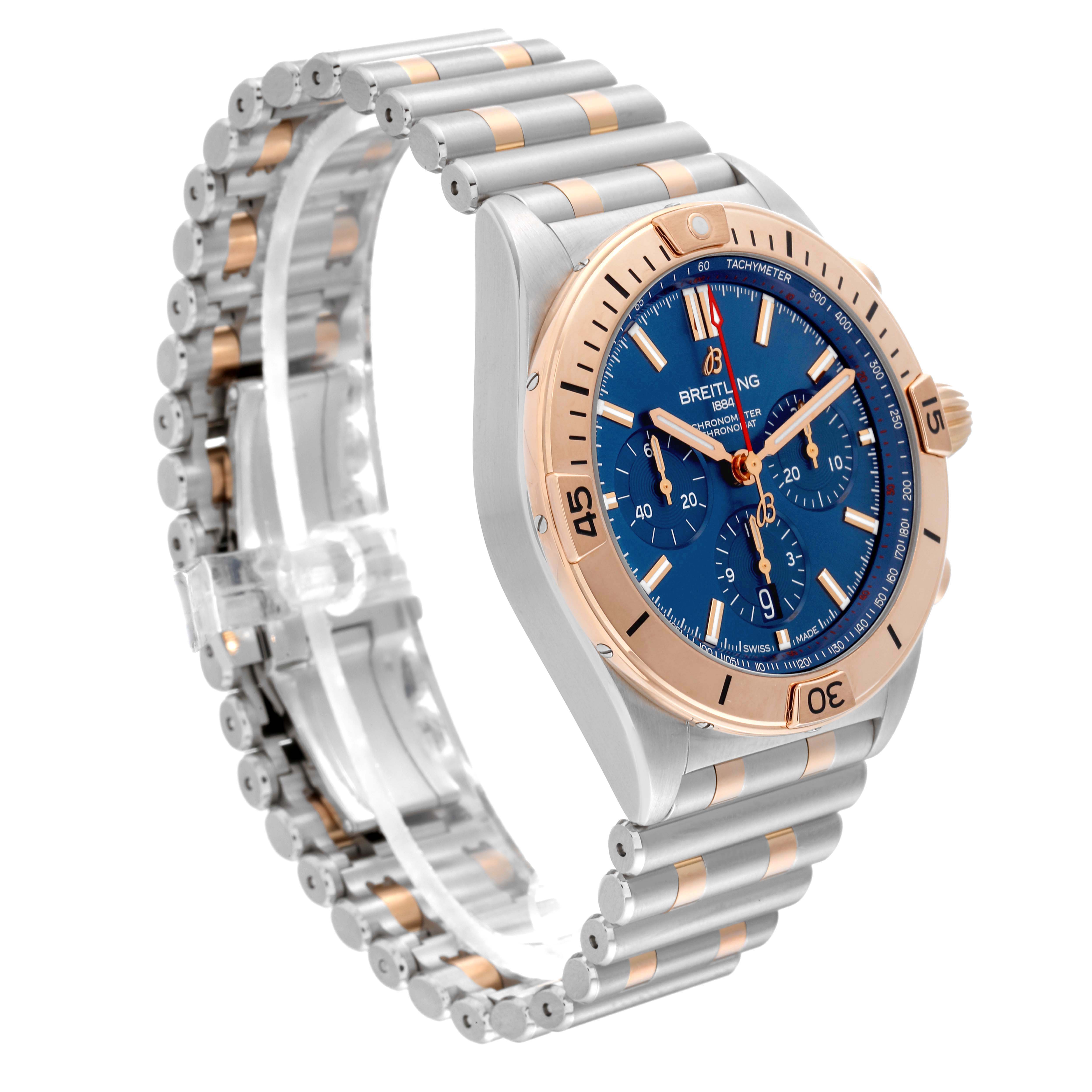 The Breitling Chronomat UB0134101C1U1 Men's Steel and Gold (two tone) Blue Dial watch is shown at an angled side view, highlighting its blue dial, rose gold bezel, and bracelet.