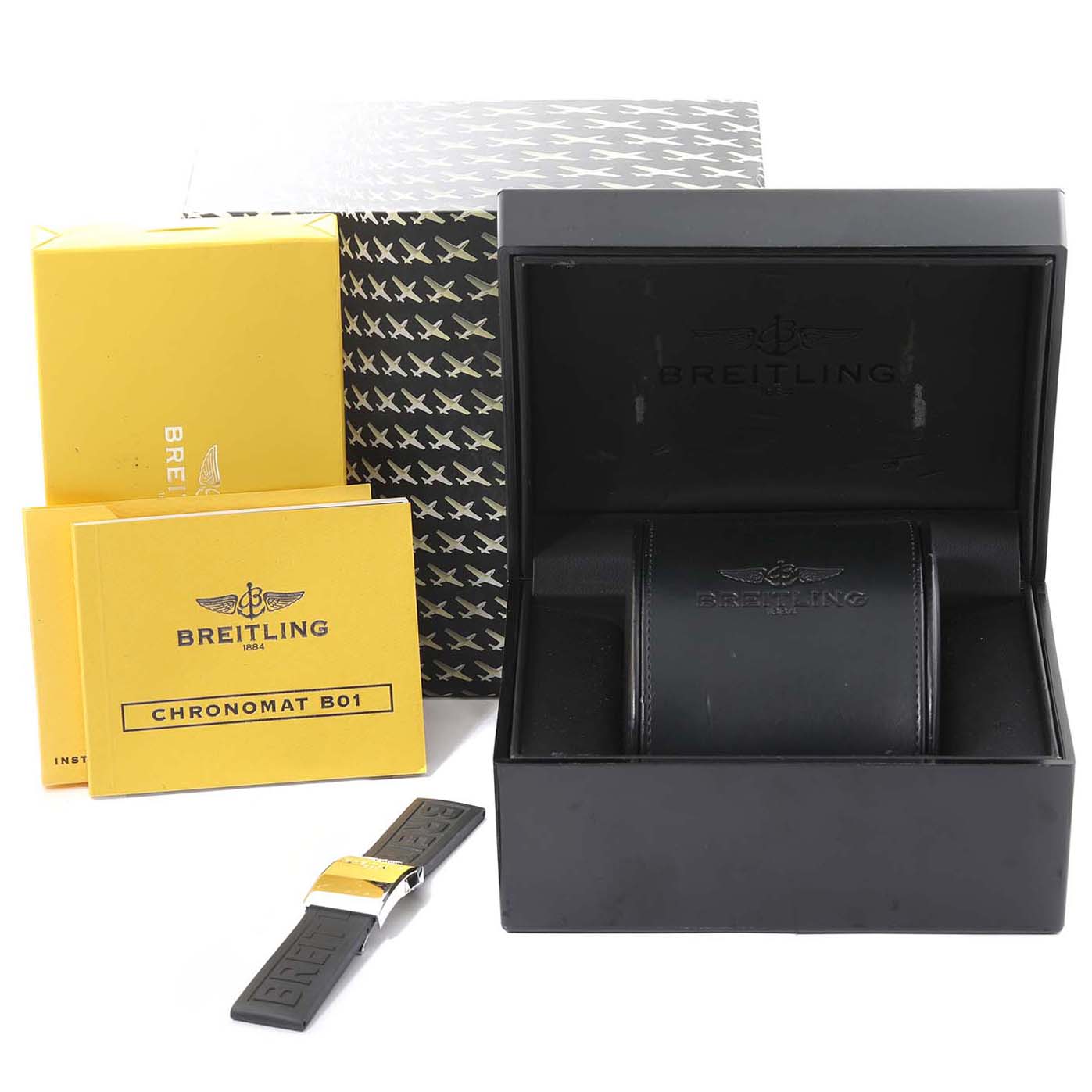 The image shows a Breitling Chronomat IB0110 Men's Stainless Steel White Dial IB0110 Men's Stainless Steel White Dial watch box, papers, and a black strap with a gold clasp, viewed from the front.
