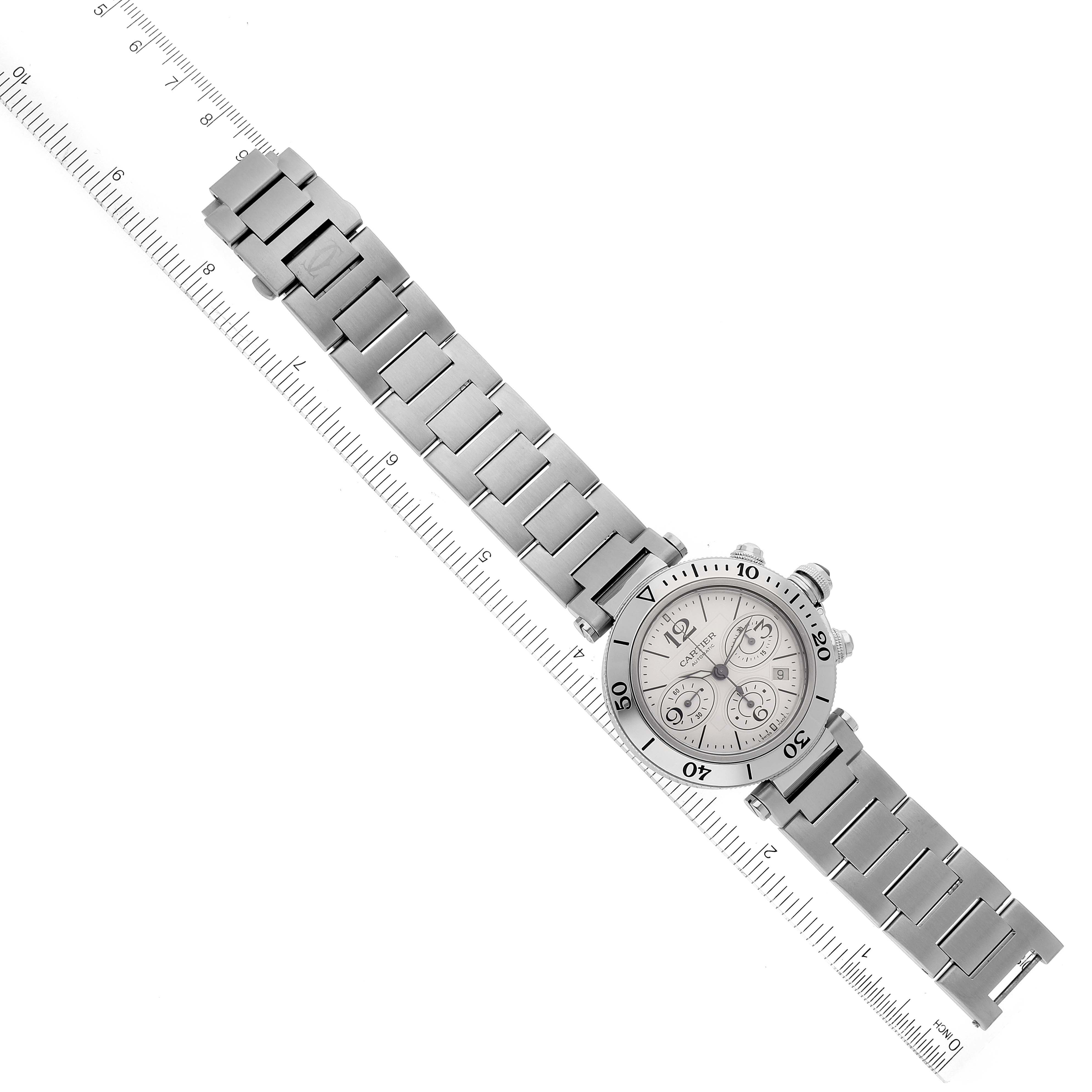 The photo shows a Cartier Pasha W31089M7 Men
s Stainless Steel Silver Dial W31089M7 Men
s Stainless Steel Silver Dial watch placed diagonally with its full metal strap laid out next to a ruler.