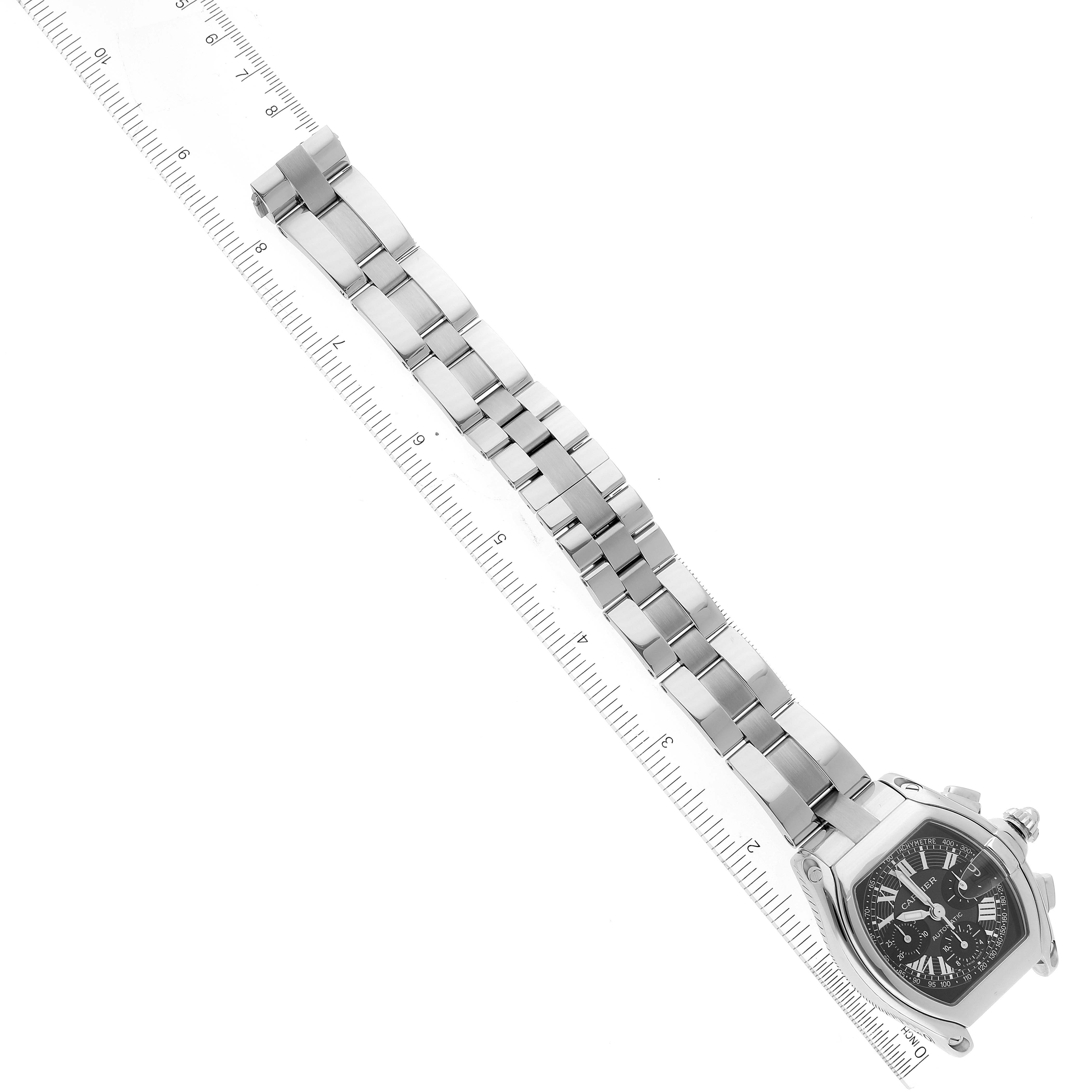 The image shows a Cartier Roadster W62007X6 Men's Stainless Steel Black Dial W62007X6 Men's Stainless Steel Black Dial watch at an angle featuring the full metal bracelet and the face alongside a ruler for scale.