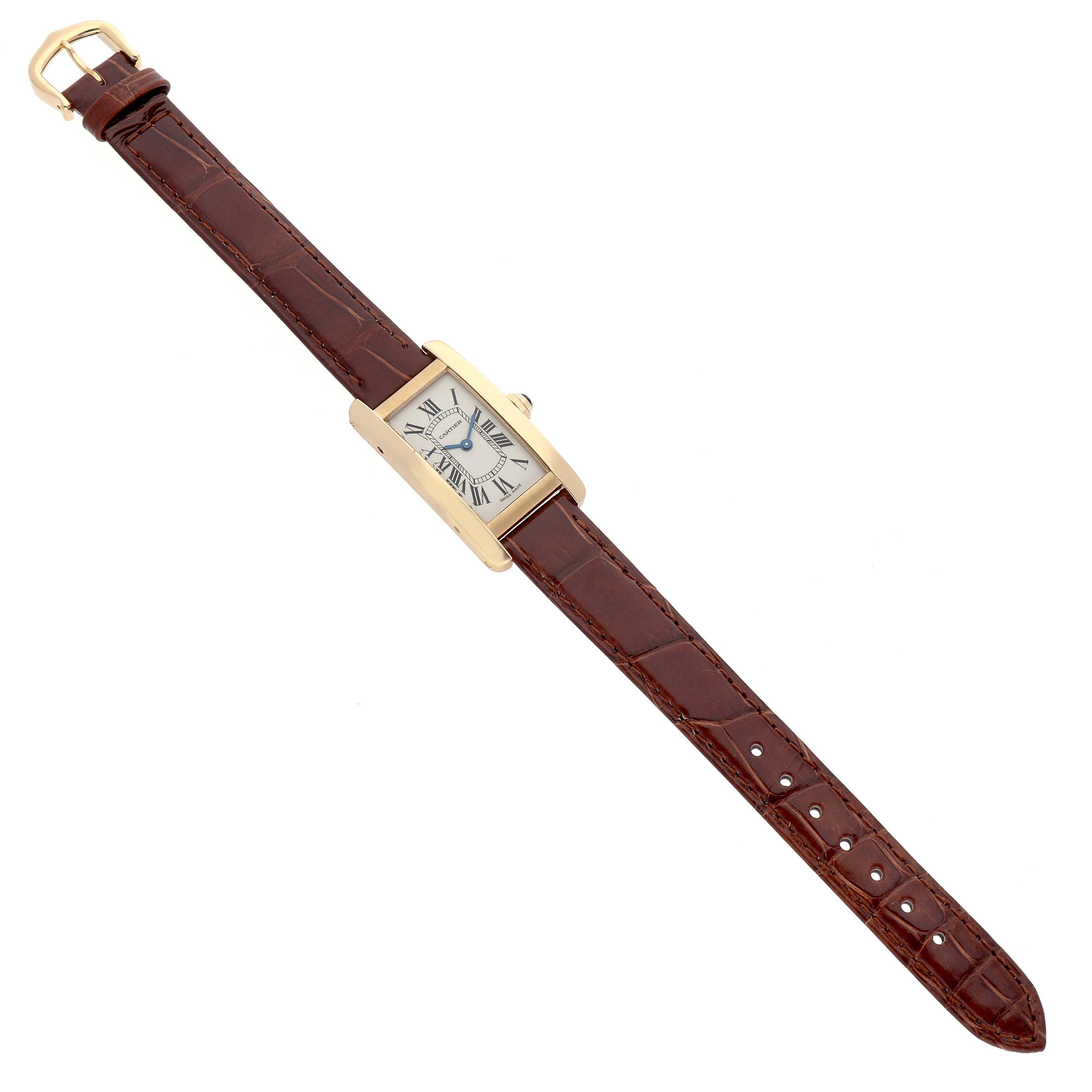 The Tank Americaine by Cartier is shown from an angled top view, showcasing the rectangular face and brown leather strap.
