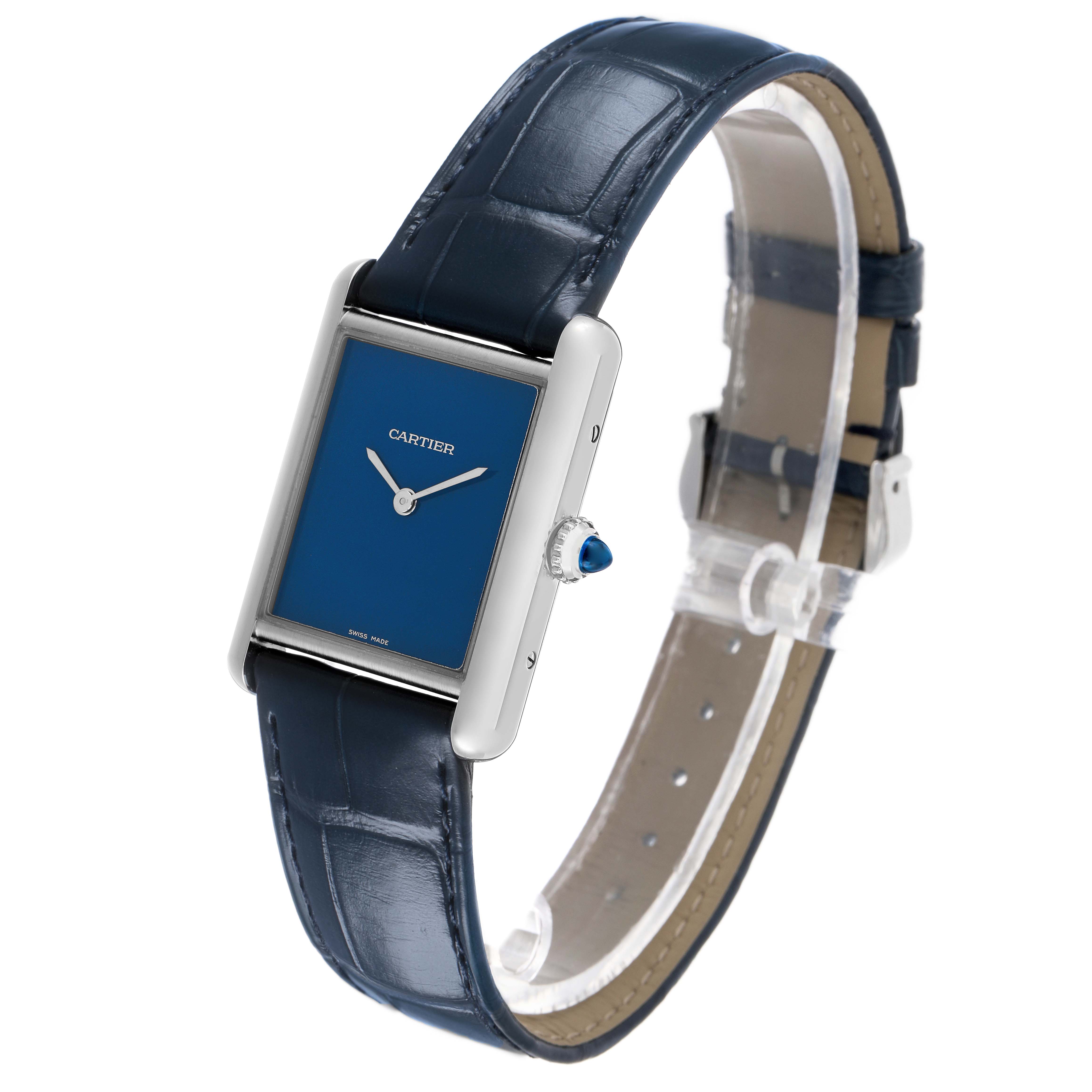 The Cartier Tank Must WSTA0055 Women's Stainless Steel Blue Dial watch is shown at an angled side view, displaying its blue dial, silver case, and dark leather strap.
