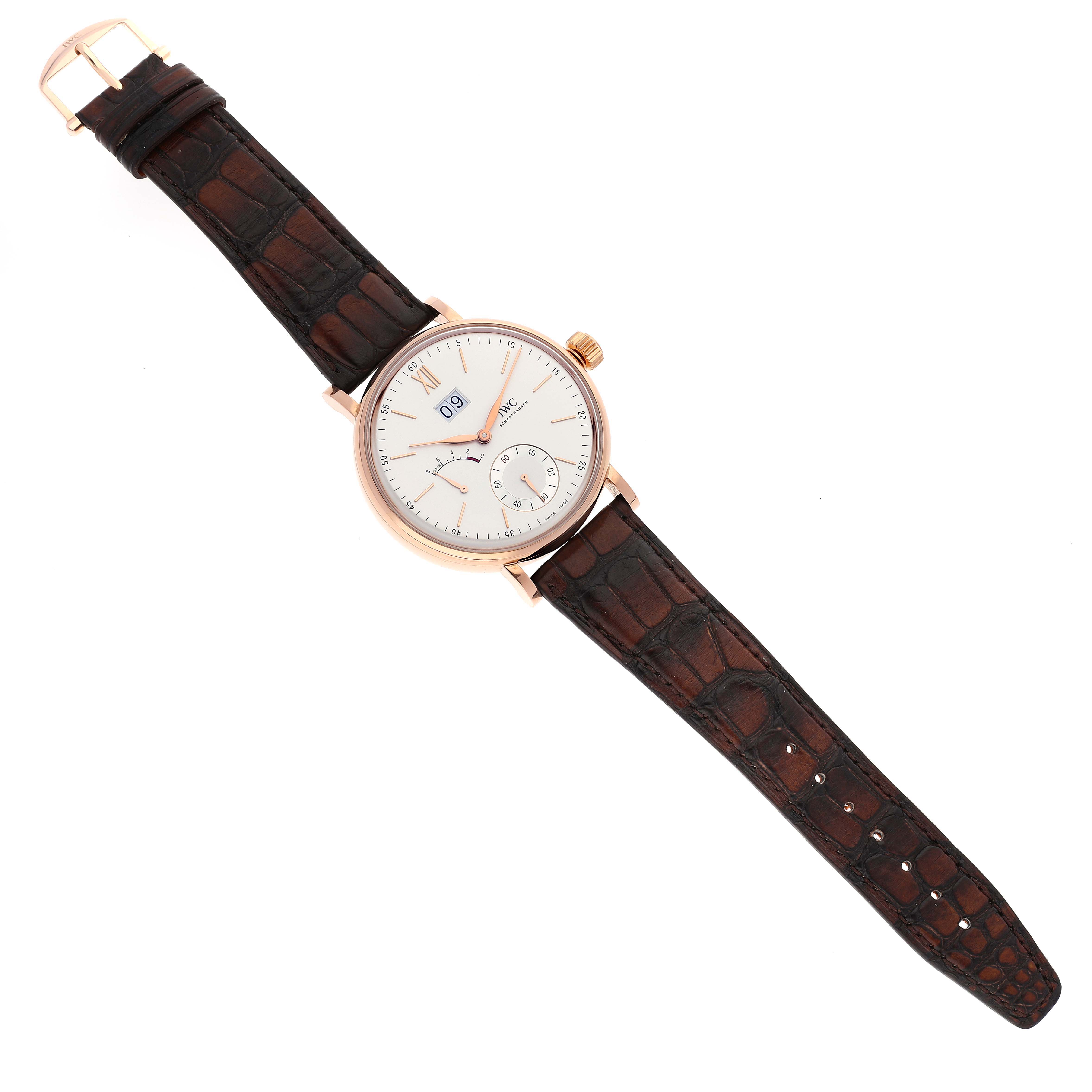The IWC Portofino IW516102 Men's Rose Gold Silver Dial IW516102 Men's Rose Gold Silver Dial watch is shown from a top-down angle, highlighting its face, crown, and brown leather strap.