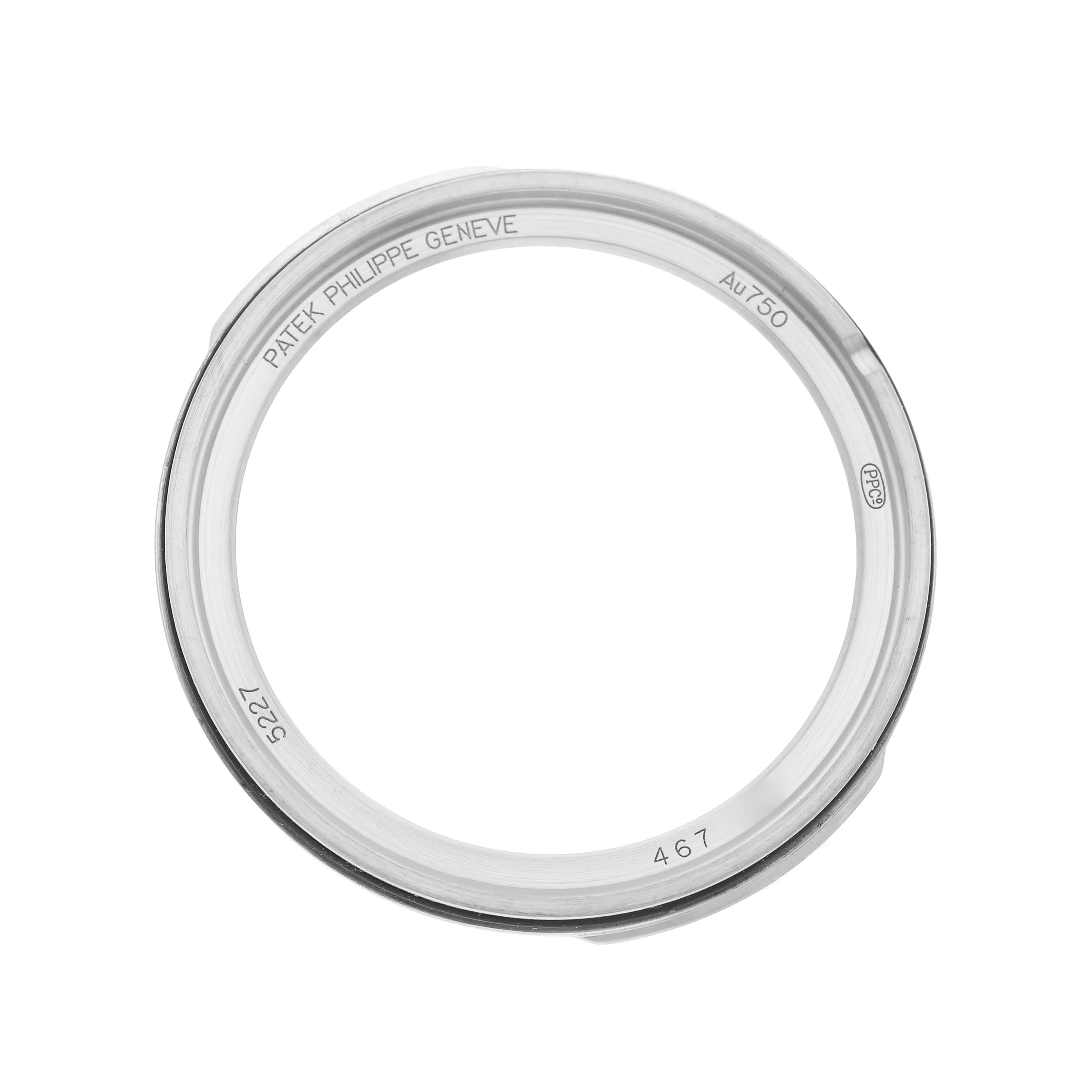 The image shows a top view of a bezel for a Patek Philippe Calatrava 5227G-010 Men's White Gold Black Dial watch, featuring engravings and markings.