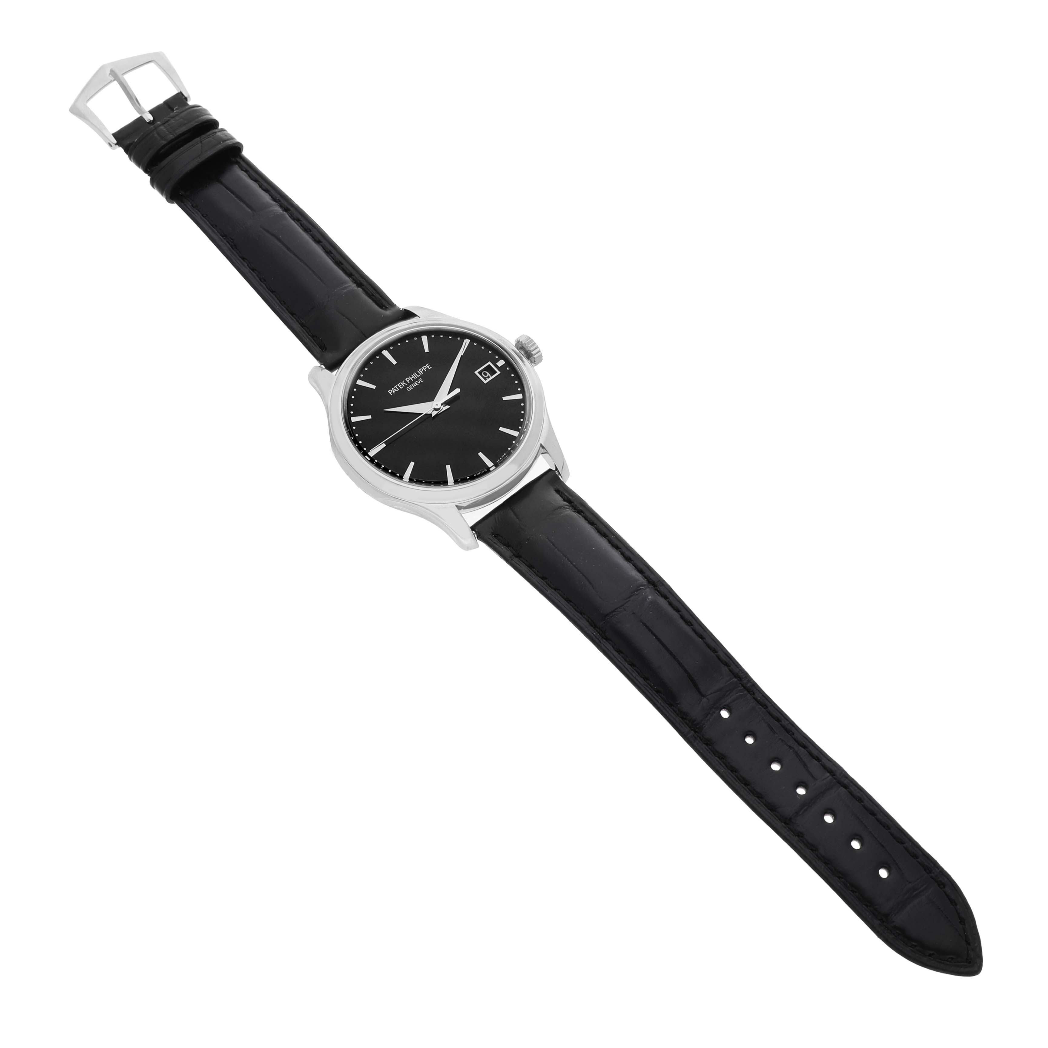 The Patek Philippe Calatrava 5227G-010 Men's White Gold Black Dial watch is shown from a top-down angle, displaying the dial, case, and leather strap.