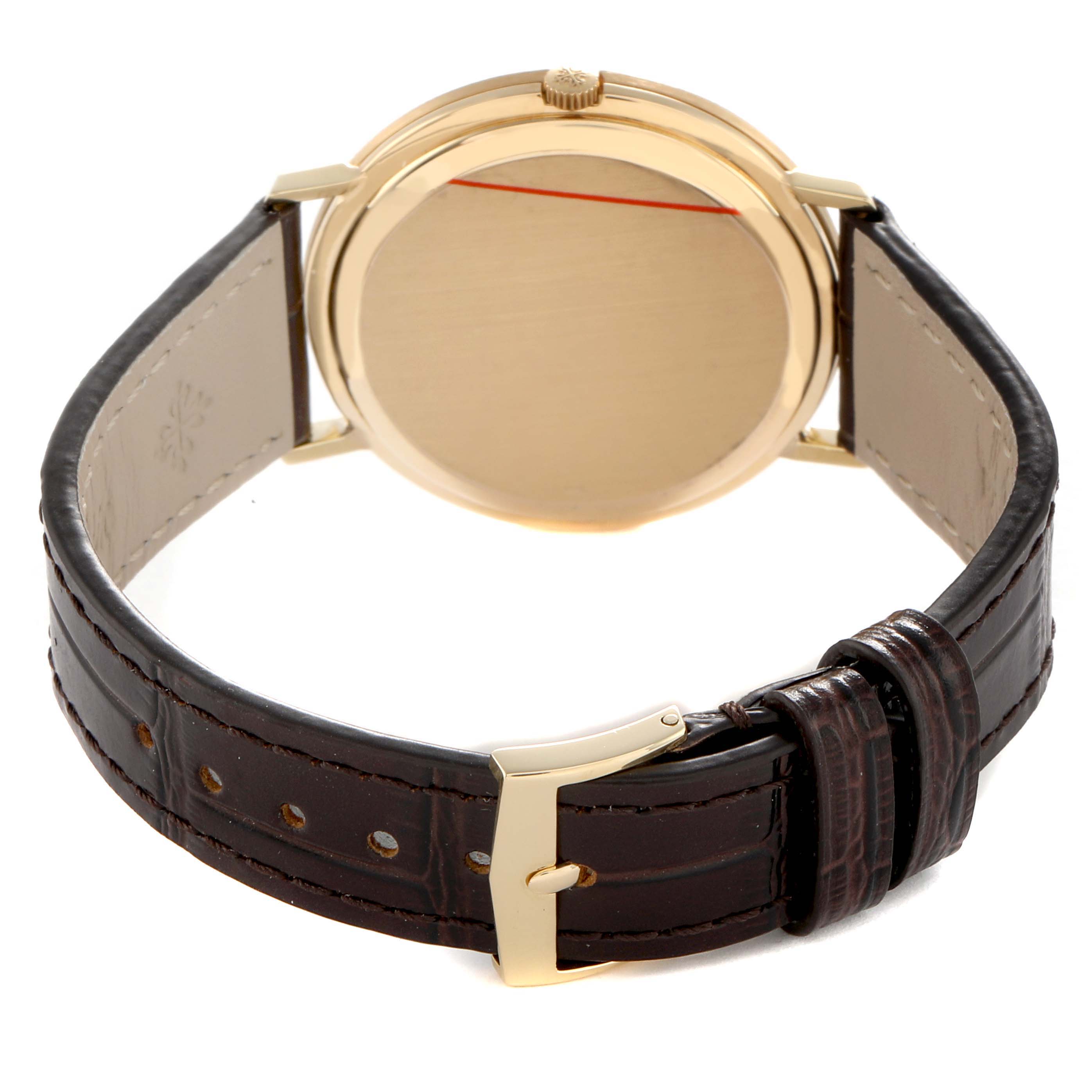 The Patek Philippe Calatrava 3588J Men's Yellow Gold Beige Dial watch is shown from the back, displaying the gold case, crown, and leather strap.