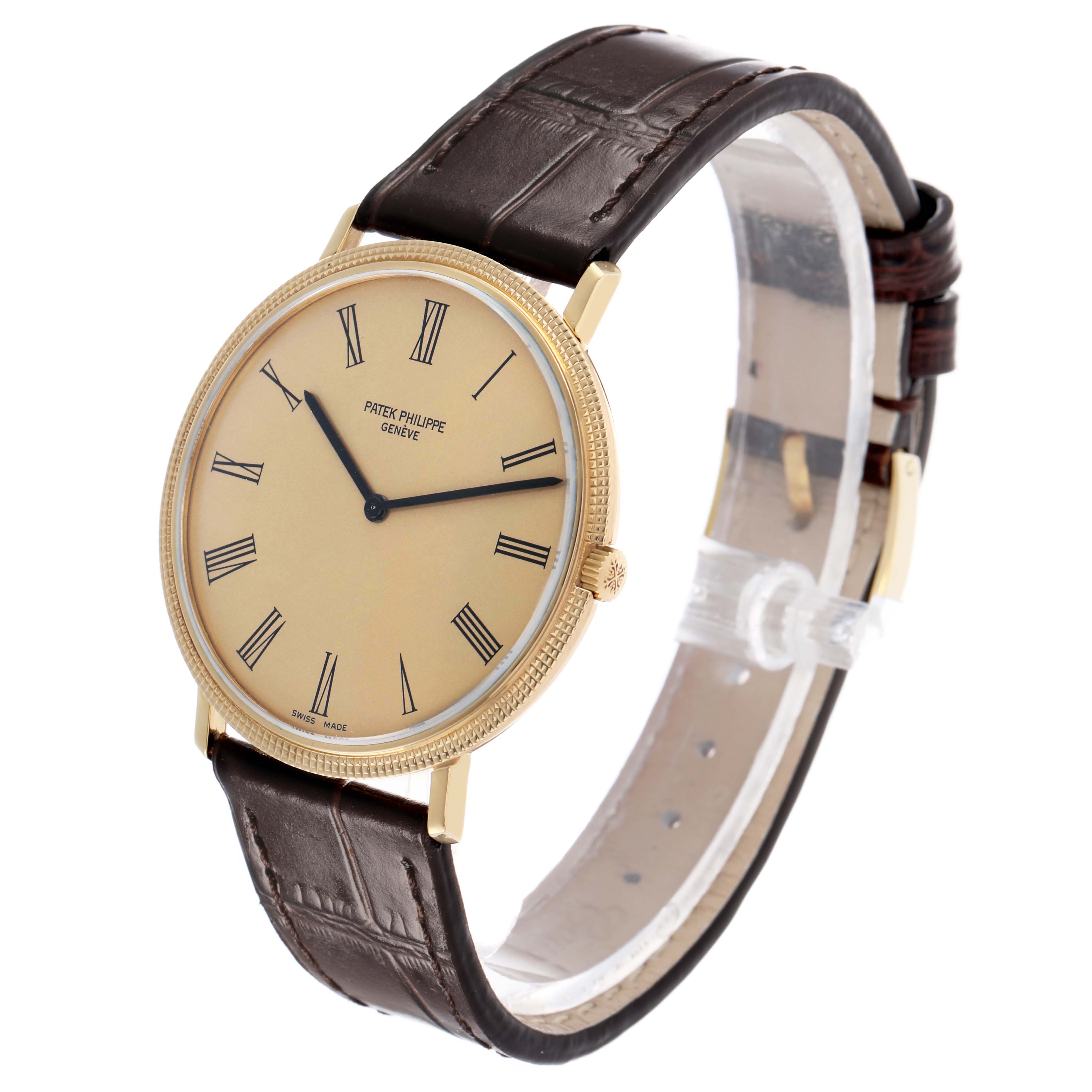 The Patek Philippe Calatrava 3588J Men's Yellow Gold Beige Dial watch is shown at an angled side view, highlighting its dial, case, crown, and leather strap.