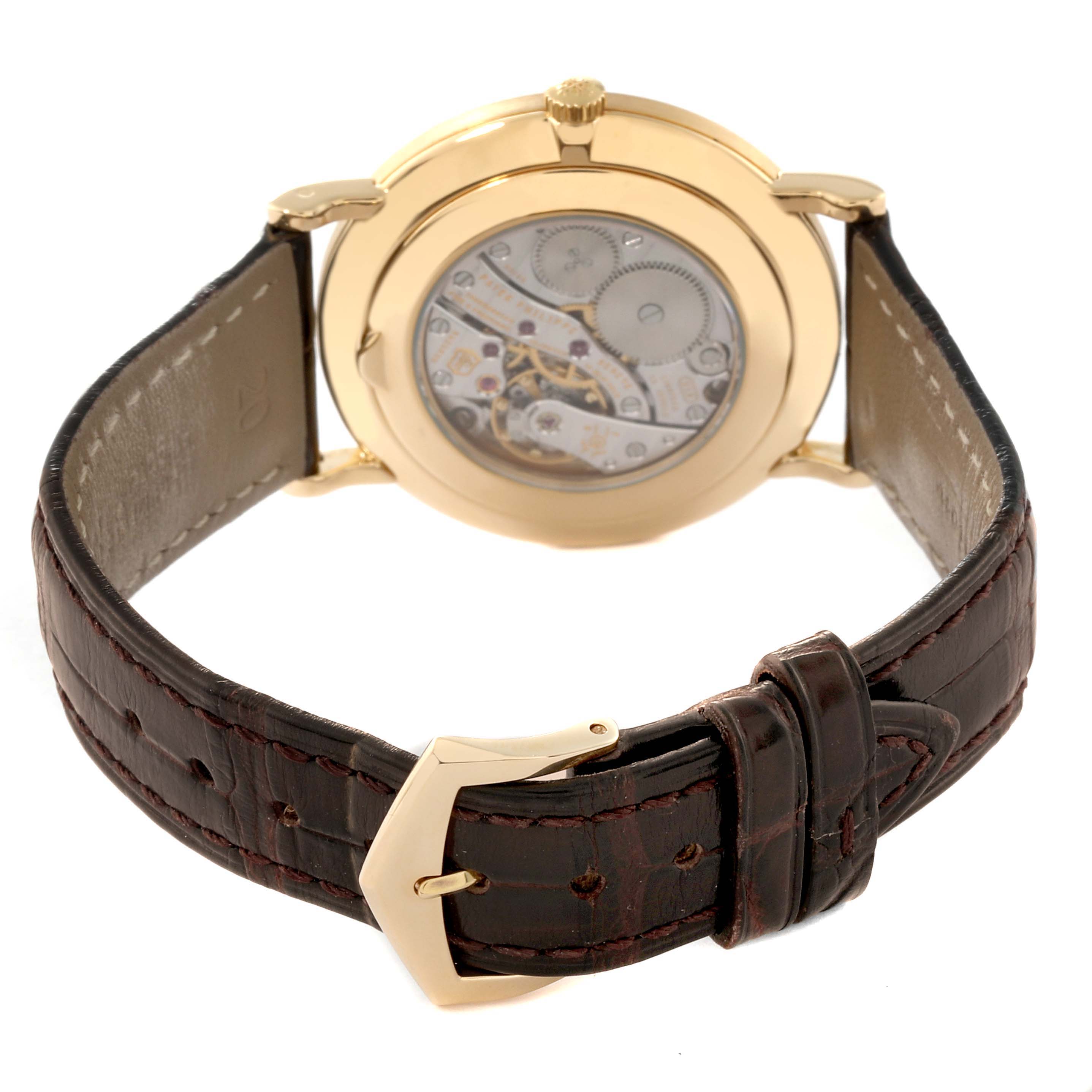 This image shows the back view of a Patek Philippe Calatrava 5119J Men's Yellow Gold White Dial 5119J Men's Yellow Gold White Dial watch, highlighting its movement and leather strap with a gold buckle.