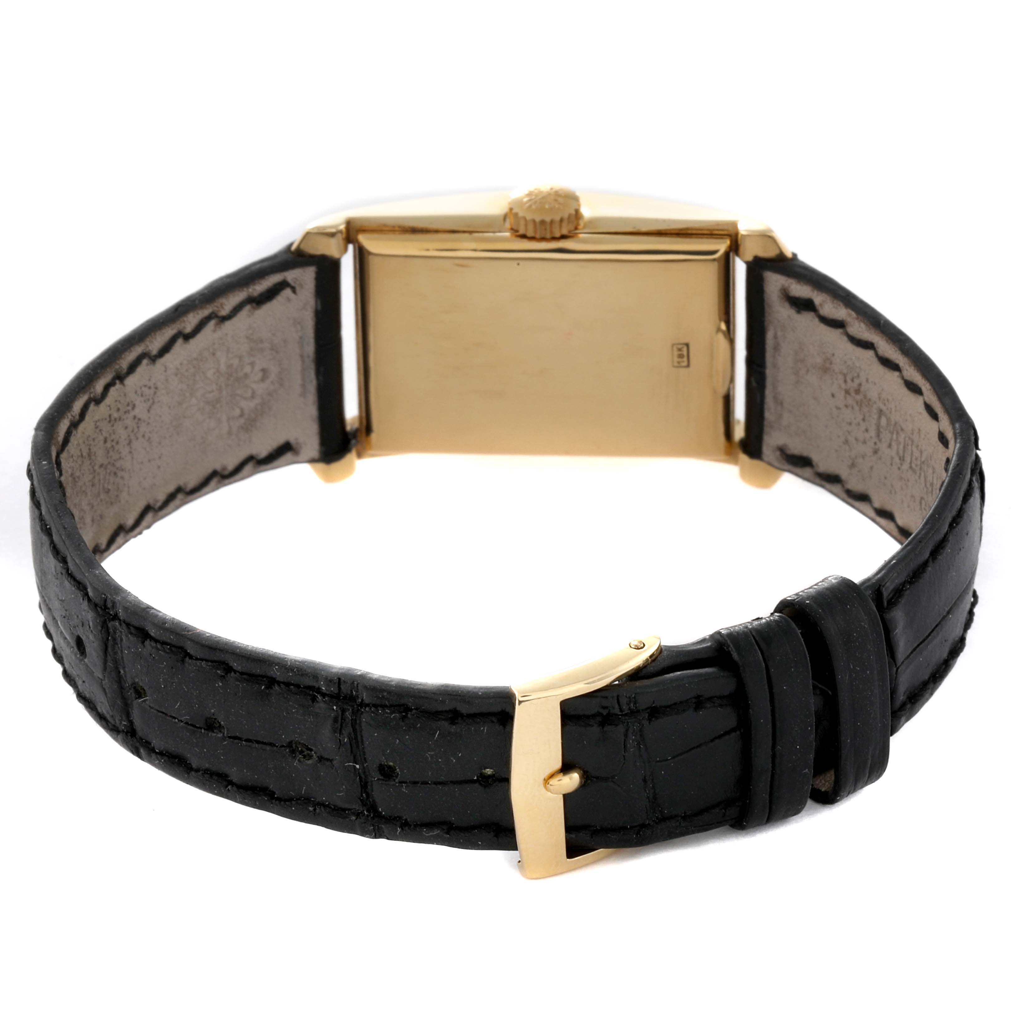 The image shows the back view of a Vintage Patek Philippe watch, highlighting its rectangular gold case and black leather strap.