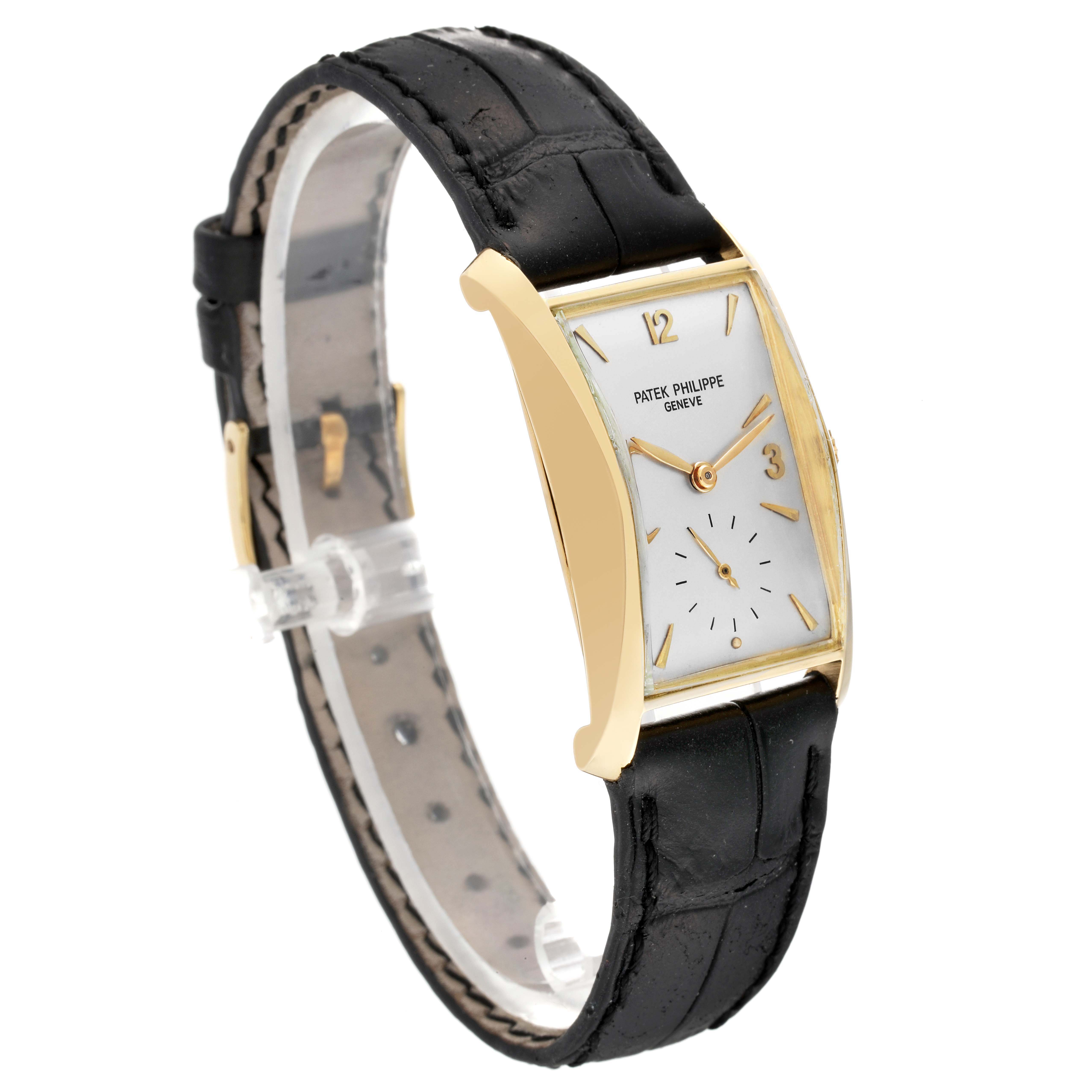 The Patek Philippe Vintage 2468 Men's Yellow Gold Silver Dial model watch is shown at a three-quarter angle, highlighting its rectangular gold case, white dial, and black leather strap.