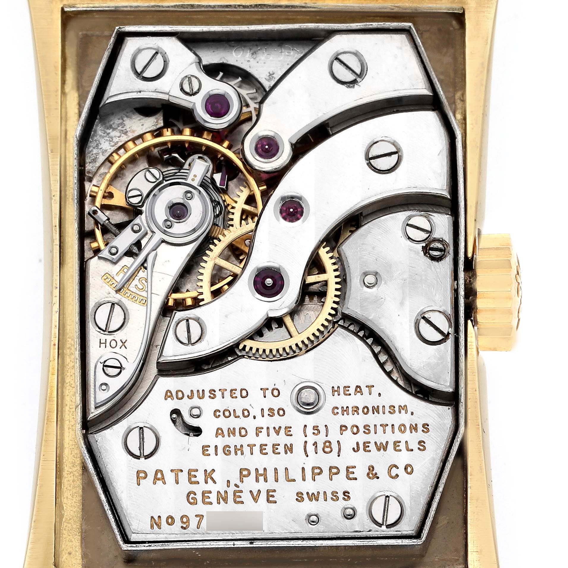The image shows the exposed movement of a Vintage Patek Philippe watch viewed from the back, showcasing gears and inscriptions.