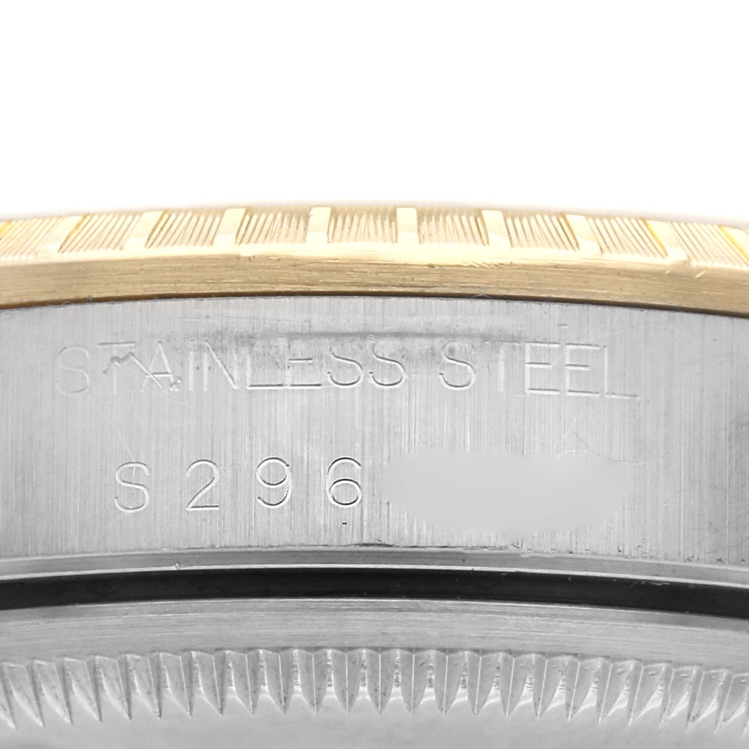 The image shows a close-up of the edge of a Rolex Date 15223 Men
s Steel and Gold (two tone) Champagne Dial 15223 Men
s Steel and Gold (two tone) Champagne Dial watch, focusing on the stainless steel case and engraved markings.