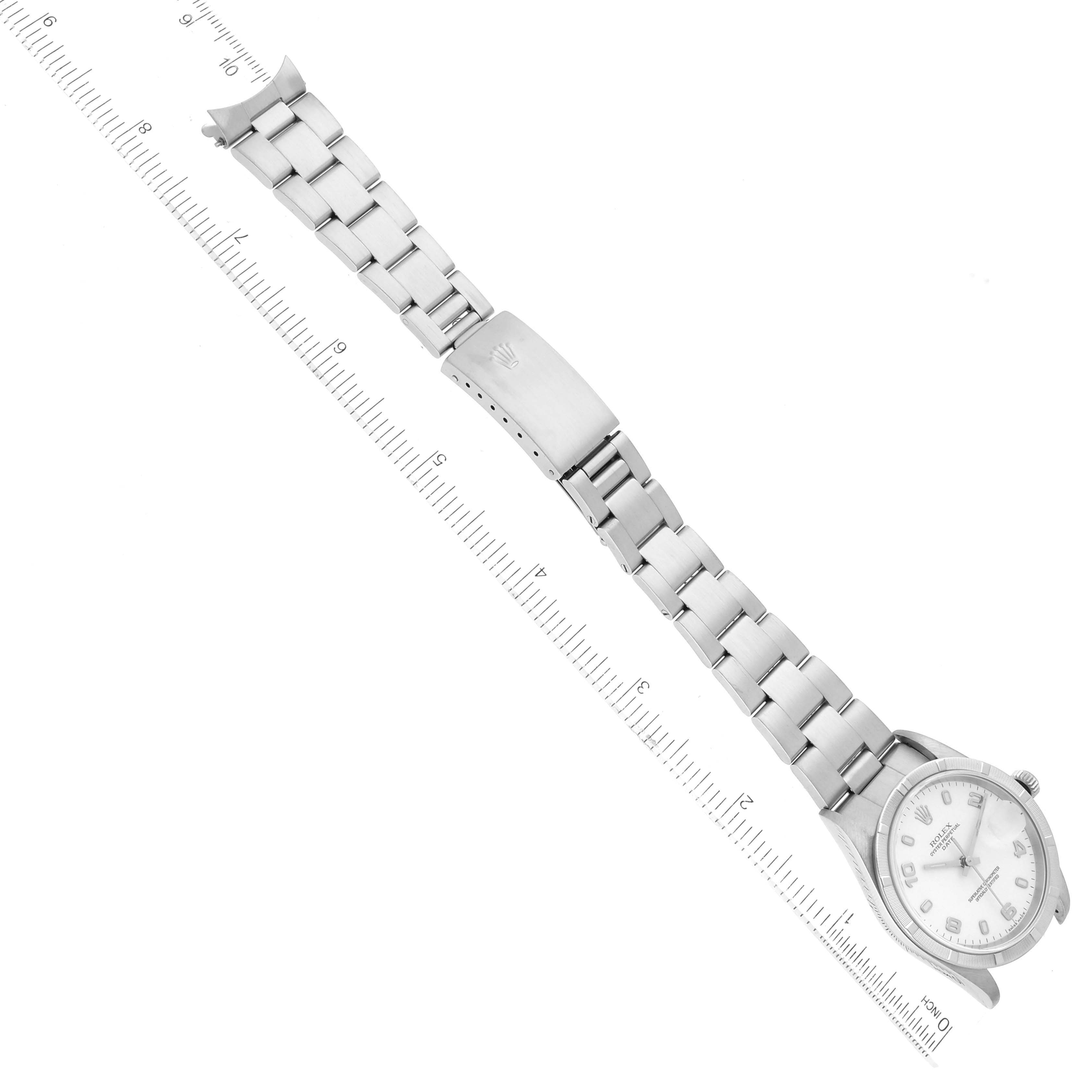 The image shows a Rolex Date 15210 Men's Stainless Steel White Dial 15210 Men's Stainless Steel White Dial model watch laid flat with its full bracelet and clasp visible, alongside a ruler for scale.