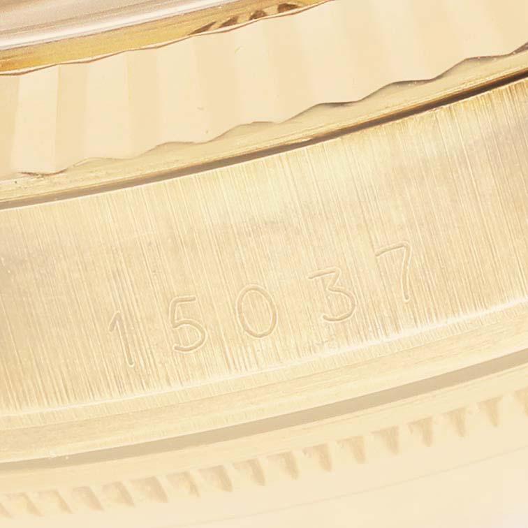 The image shows a close-up of the side of a Rolex Date 15037 Men's Yellow Gold Champagne Dial model watch, focusing on the engraved serial number on the case.