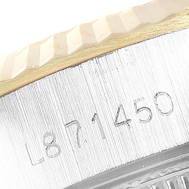 This close-up image shows the etched serial number on the case and the fluted bezel of a Rolex Datejust 69173 Women
s Steel and Gold (two tone) Champagne Dial 69173 Women
s Steel and Gold (two tone) Champagne Dial watch.