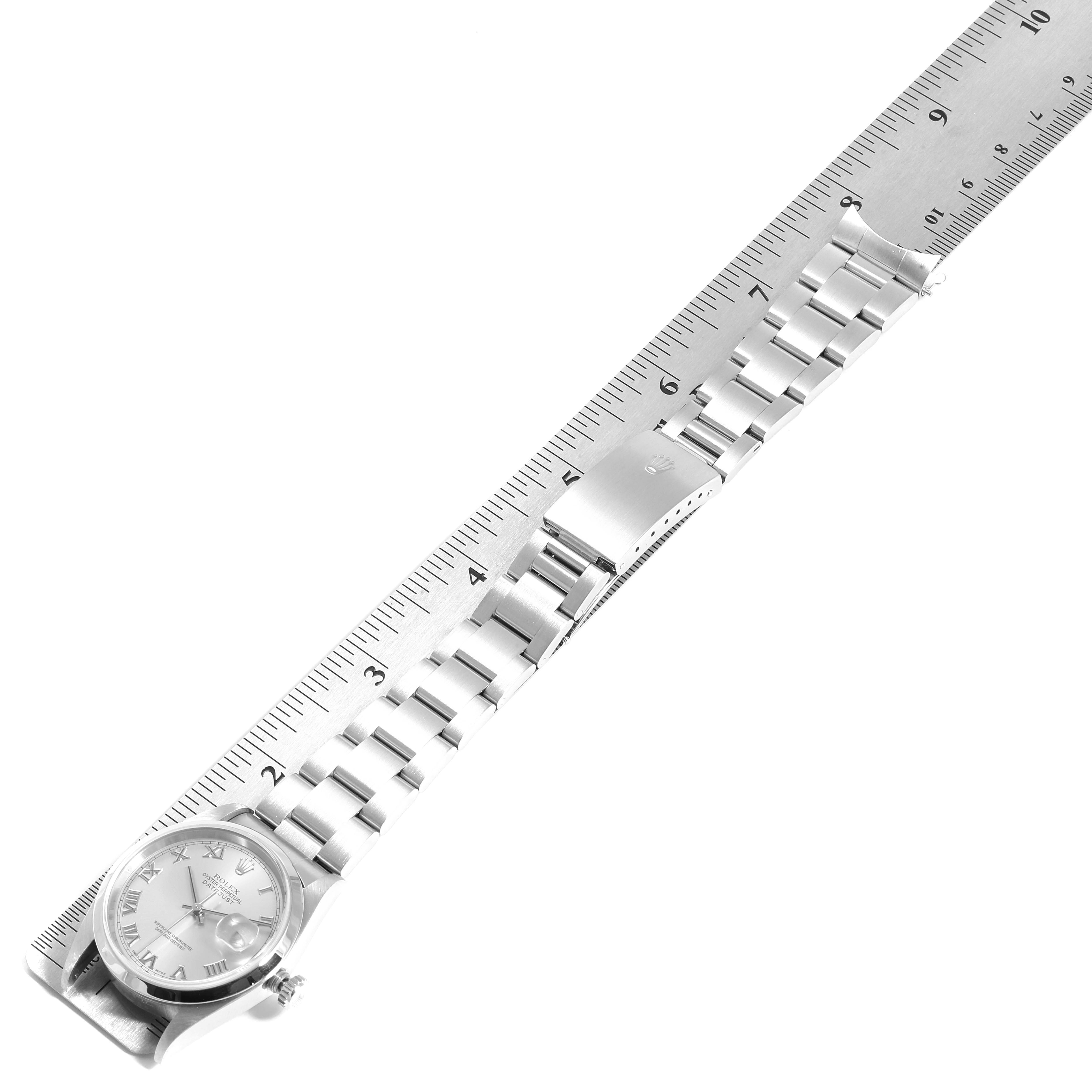 This image shows a Rolex Datejust 16200 Men
s Stainless Steel Grey Dial 16200 Men
s Stainless Steel Grey Dial watch laid flat with a ruler, displaying the bracelet and part of the face.