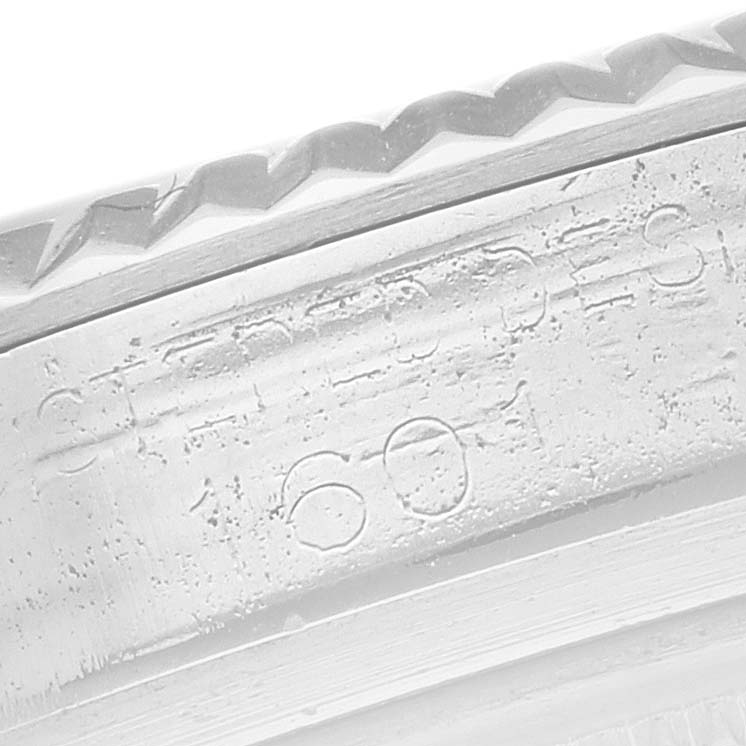 The image shows a close-up of the Rolex Datejust 1601 Men
s Stainless Steel Silver Dial 1601 Men
s Stainless Steel Silver Dial model
s engraved bezel and rehaut.