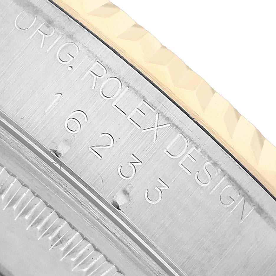 The image shows a close-up of the Rolex Datejust 16233 Men's Steel and Gold (two tone) White Dial's case side with engraved serial numbers and design detail.