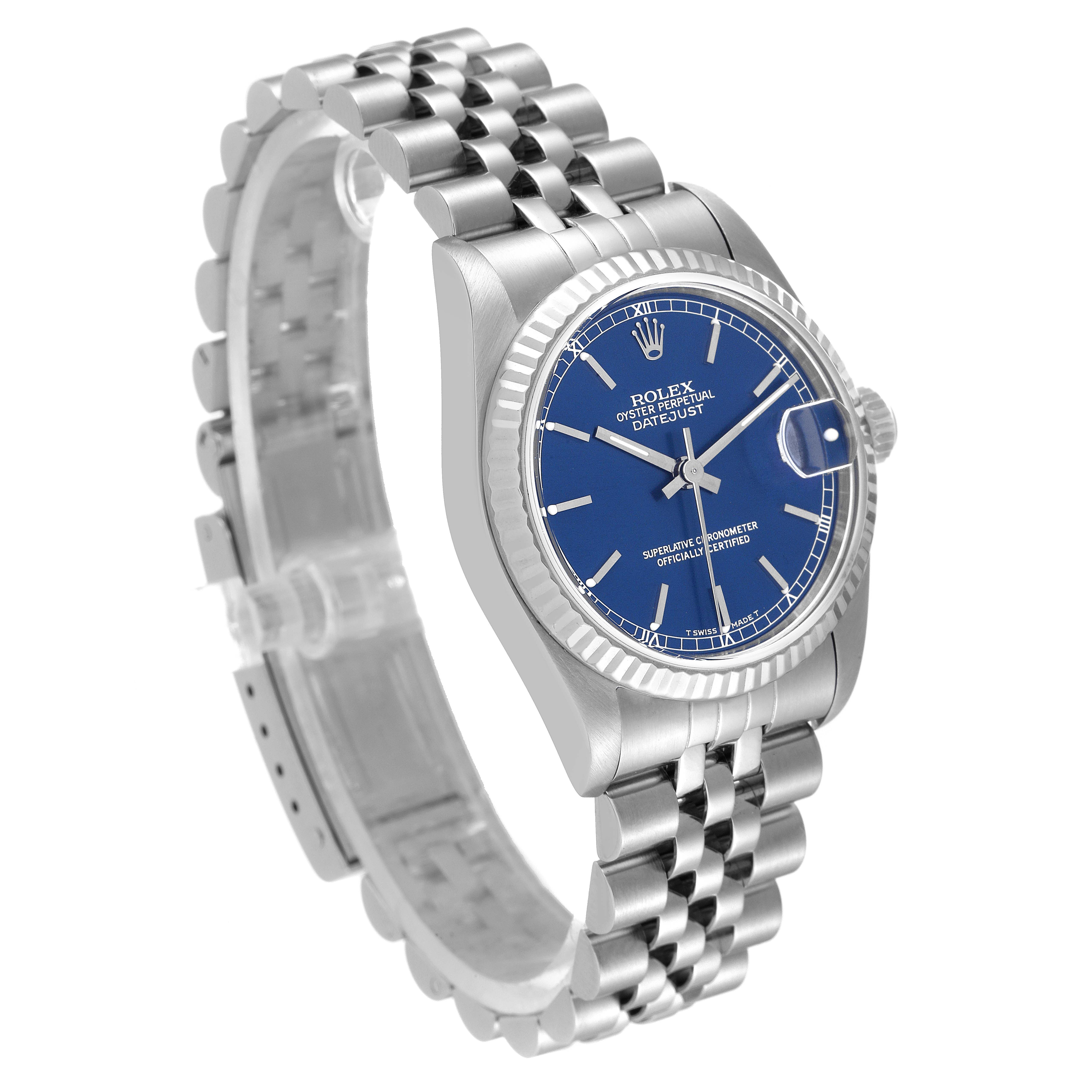 This image shows an angled view of a Mid-Size Rolex Datejust watch, highlighting the blue dial, fluted bezel, and Jubilee bracelet.