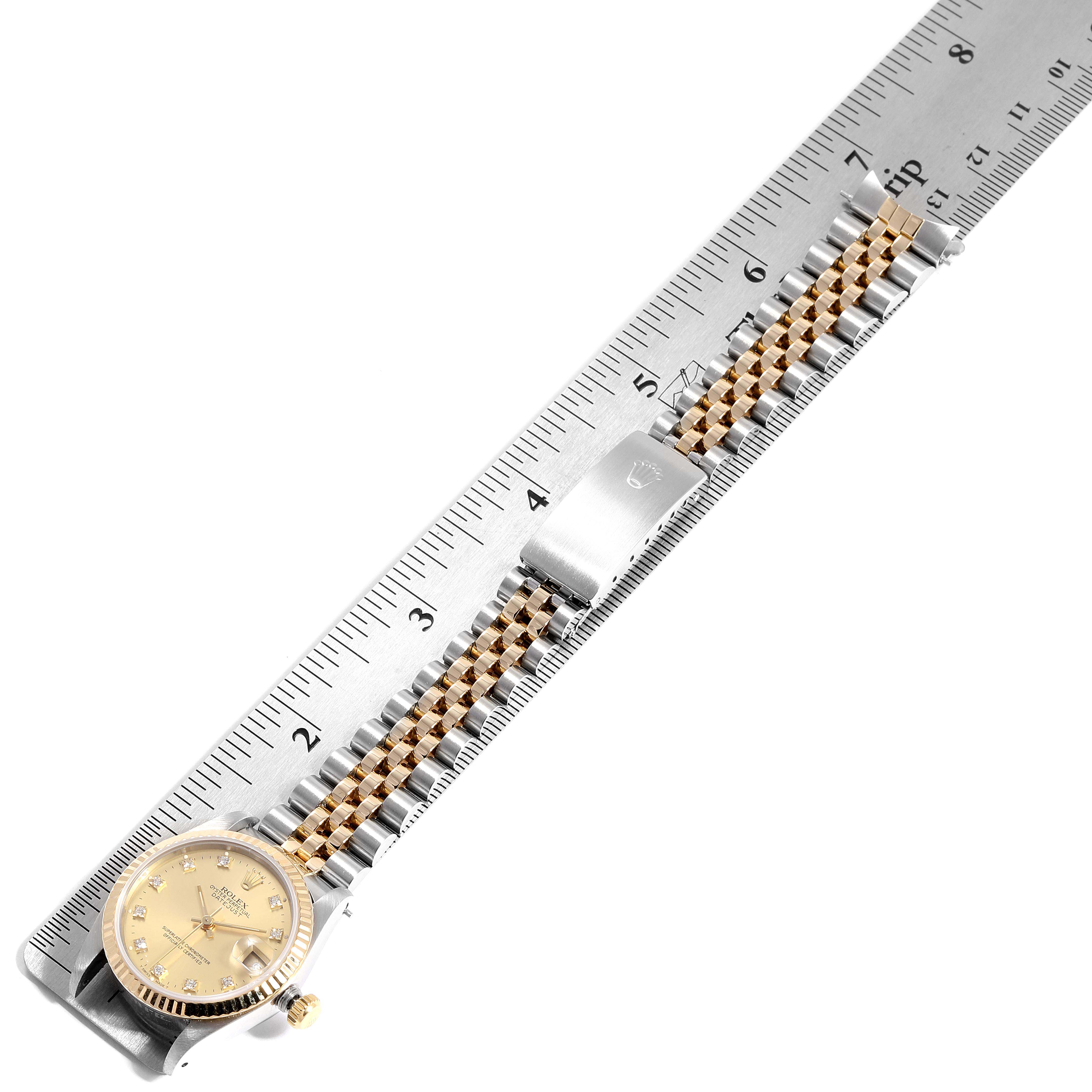 This image shows a Rolex Mid-Size 68273 Women
s Steel and Gold (two tone) Champagne Dial 68273 Women
s Steel and Gold (two tone) Champagne Dial watch with a gold dial and two-tone bracelet, measured against a ruler.