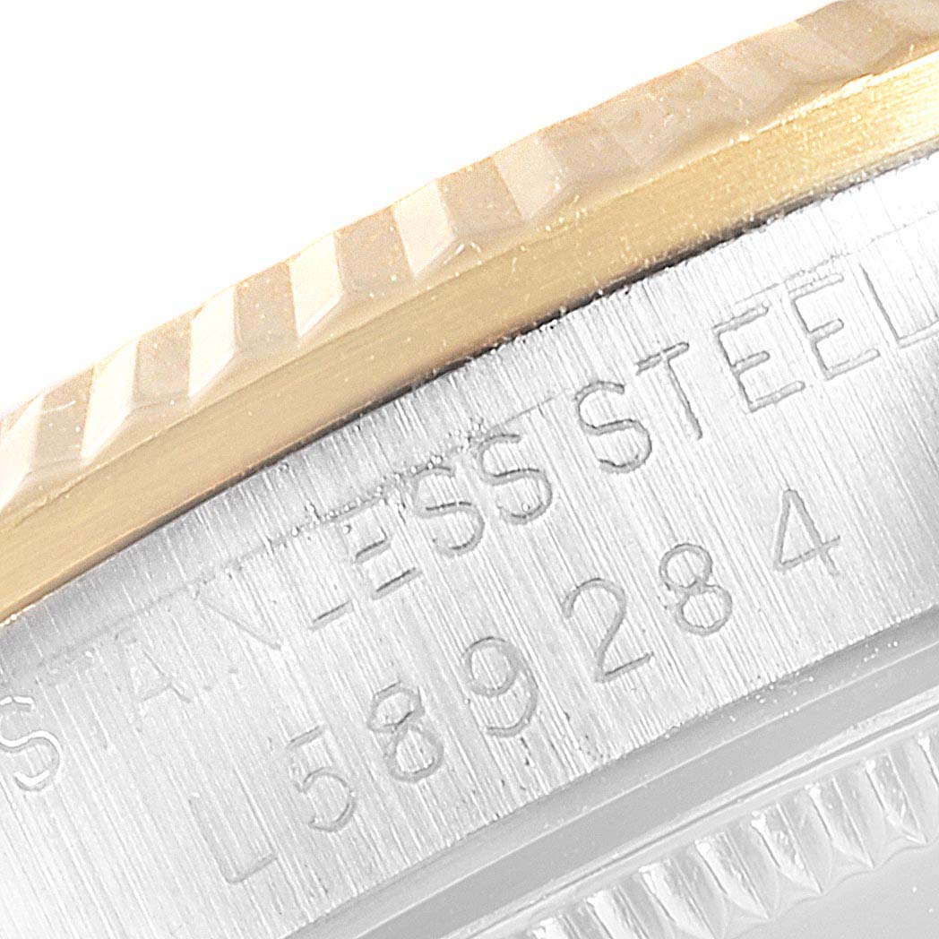 This image shows a close-up angle of the case and the fluted bezel of a Mid-Size Rolex watch, highlighting the stainless steel.