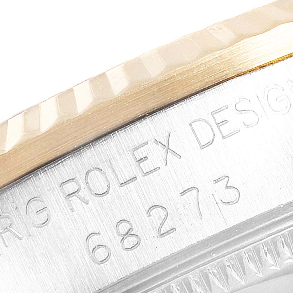 This close-up image shows the engraved side bezel and edge of a Mid-Size Rolex watch.