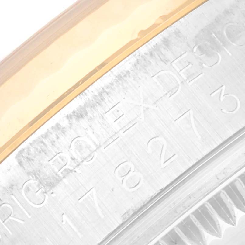 This close-up image of a Mid-Size Rolex watch shows the engraved side of the case along with part of the bezel.