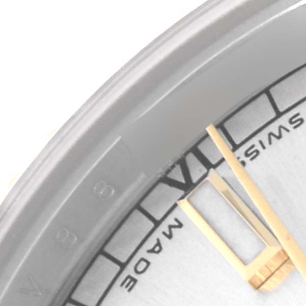 This close-up image of the Rolex Mid-Size 178273 Women's Steel and Gold (two tone) Silver Dial 178273 Women's Steel and Gold (two tone) Silver Dial model shows part of the watch face, including the Roman numeral VI, and the hour and minute hands.