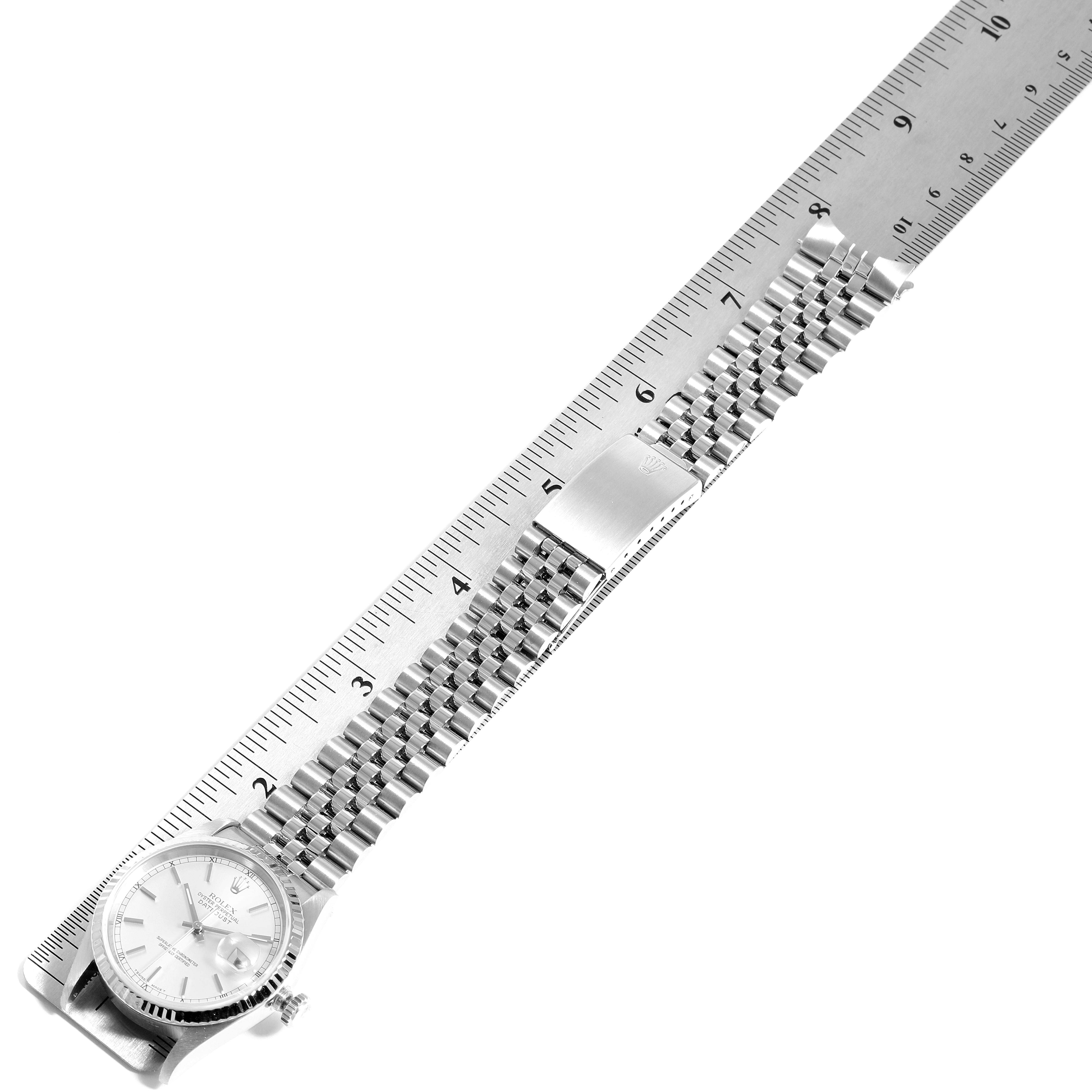 The image shows a Rolex Datejust 16234 Men's Stainless Steel Silver Dial 16234 Men's Stainless Steel Silver Dial watch laid flat alongside a ruler, displaying the face, bracelet, and clasp.