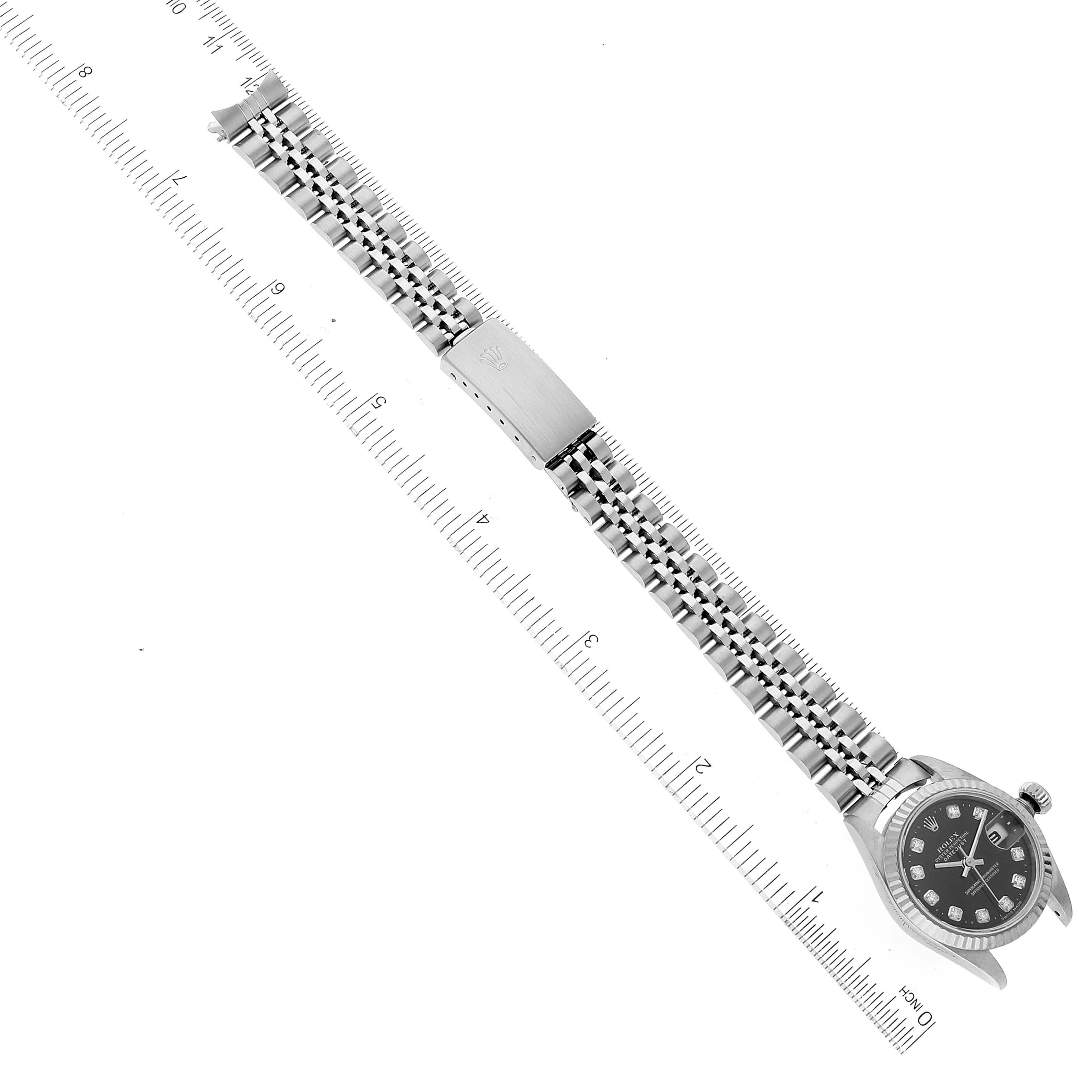 This image shows a Rolex Datejust 79174 Women's Stainless Steel Black Dial 79174 Women's Stainless Steel Black Dial watch displayed flat with a ruler for scale, focusing on the bracelet and the watch face.