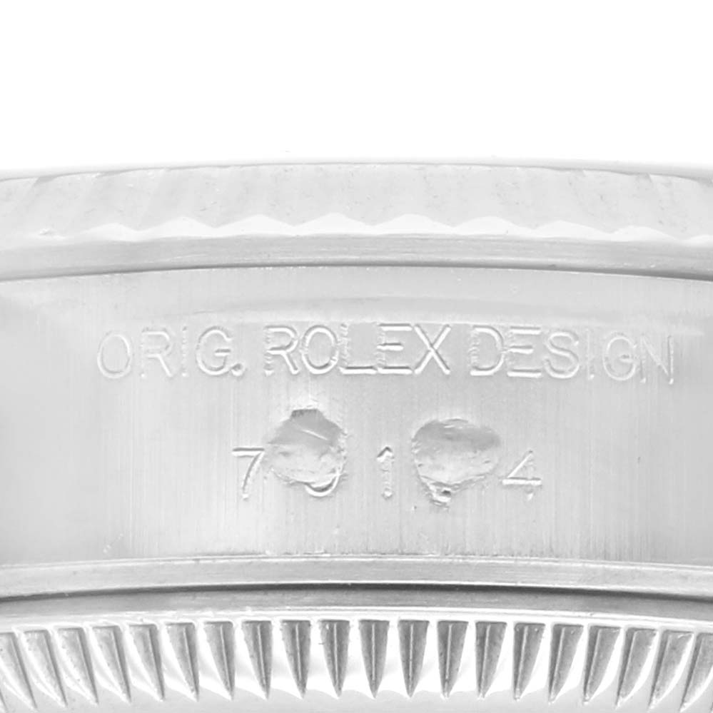 The image shows a close-up of the Rolex Datejust 79174 Women
s Stainless Steel White Dial 79174 Women
s Stainless Steel White Dial
s engraved case band and fluted bezel.