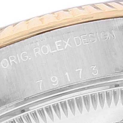 This image shows a close-up of the Rolex Datejust 79173 Women's Steel and Gold (two tone) Black Dial 79173 Women's Steel and Gold (two tone) Black Dial model's casing with engravings visible.
