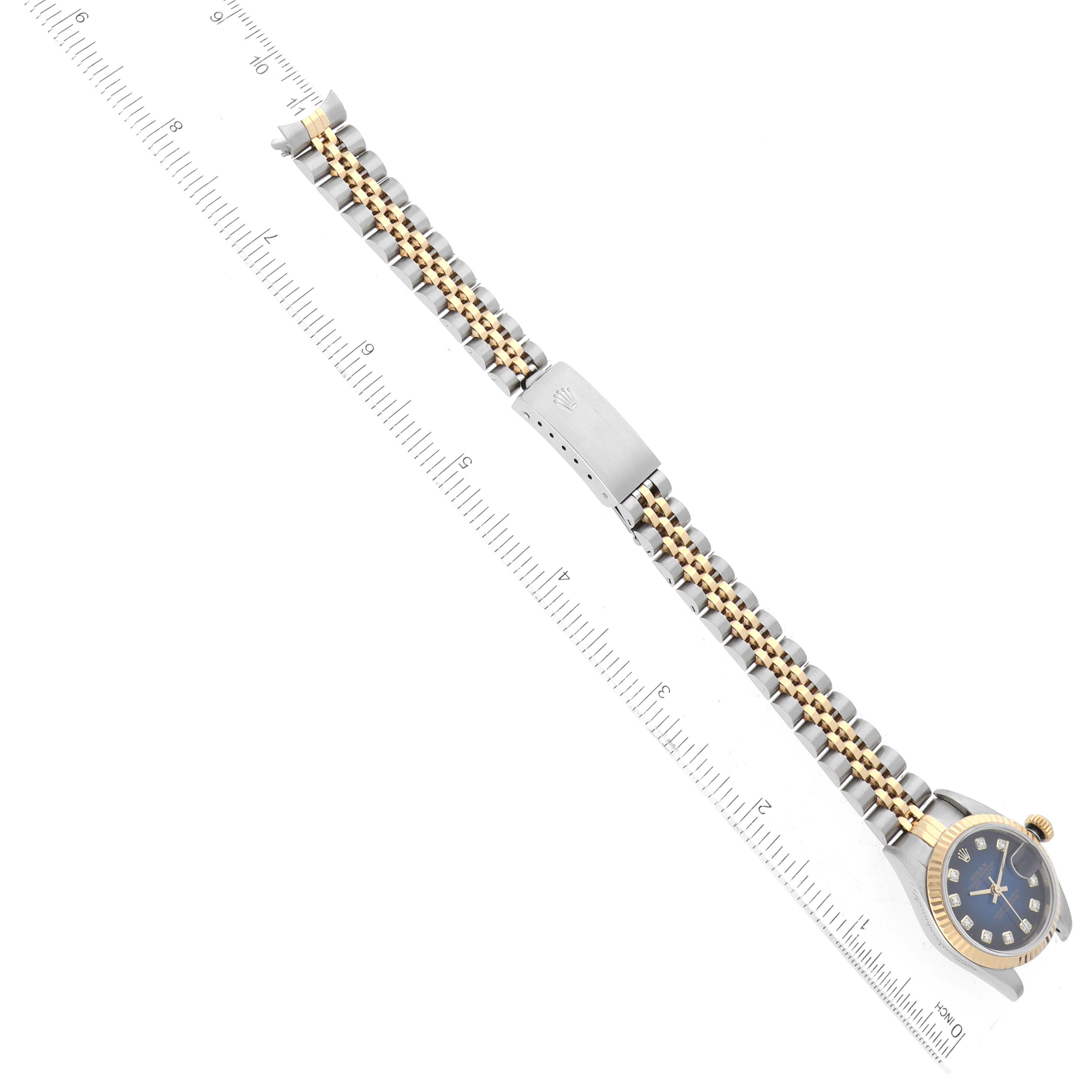 The image shows a Rolex Datejust 79173 Women's Steel and Gold (two tone) Blue Dial 79173 Women's Steel and Gold (two tone) Blue Dial watch laid flat, highlighting the bracelet, clasp, and partial case with a ruler for scale.